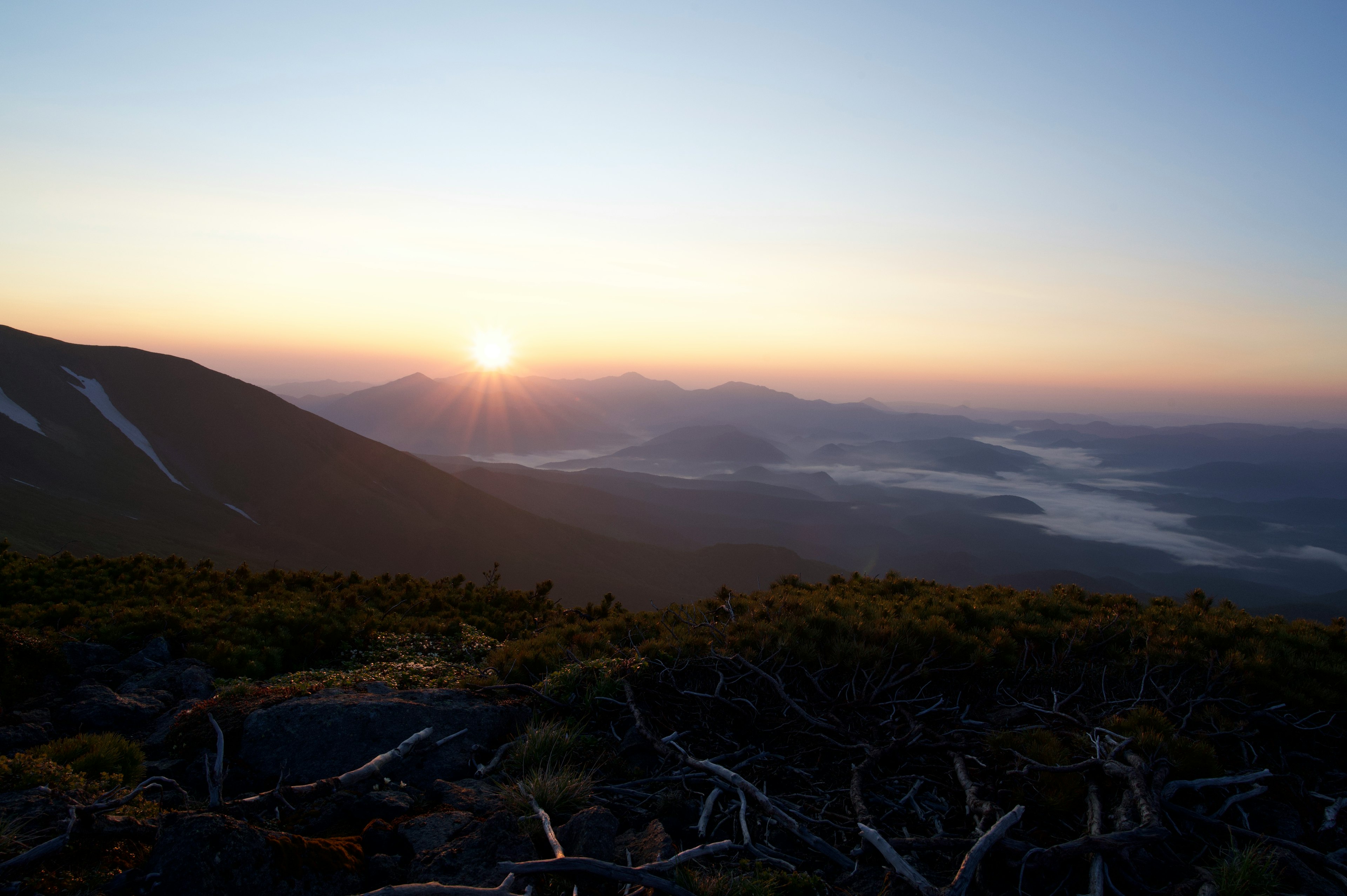 Schöne Landschaft mit der Sonne, die zwischen den Bergen aufgeht