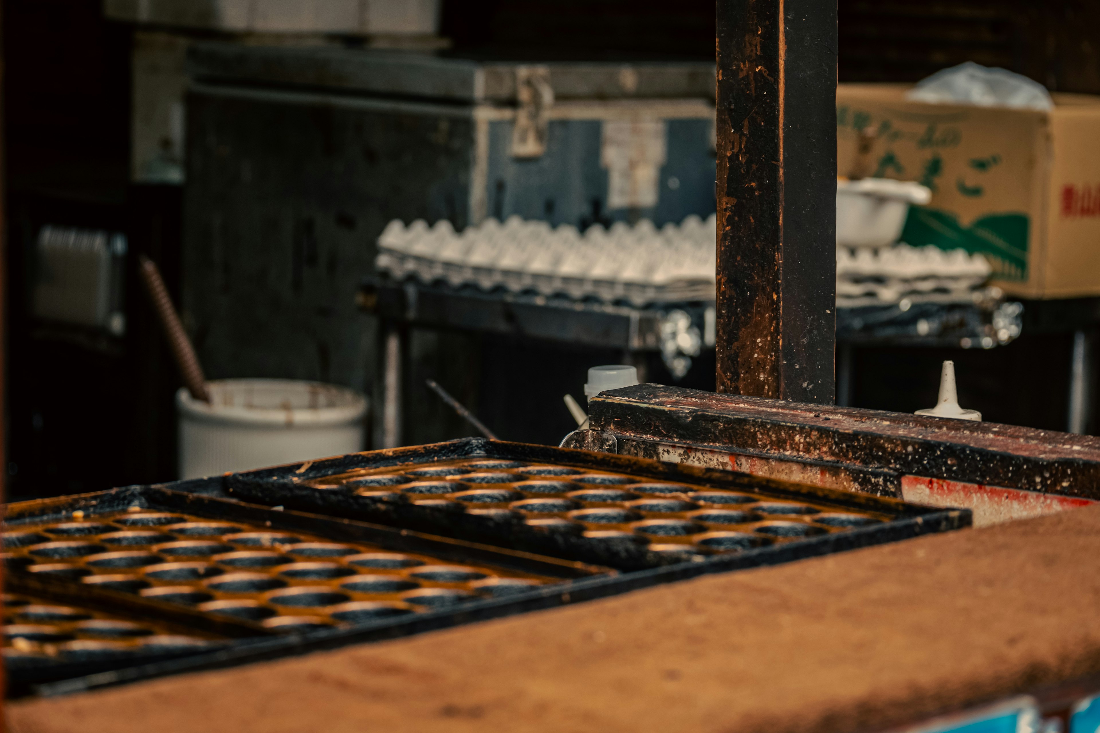 Ruang kerja dapur tua dengan loyang dan kemasan telur di latar belakang