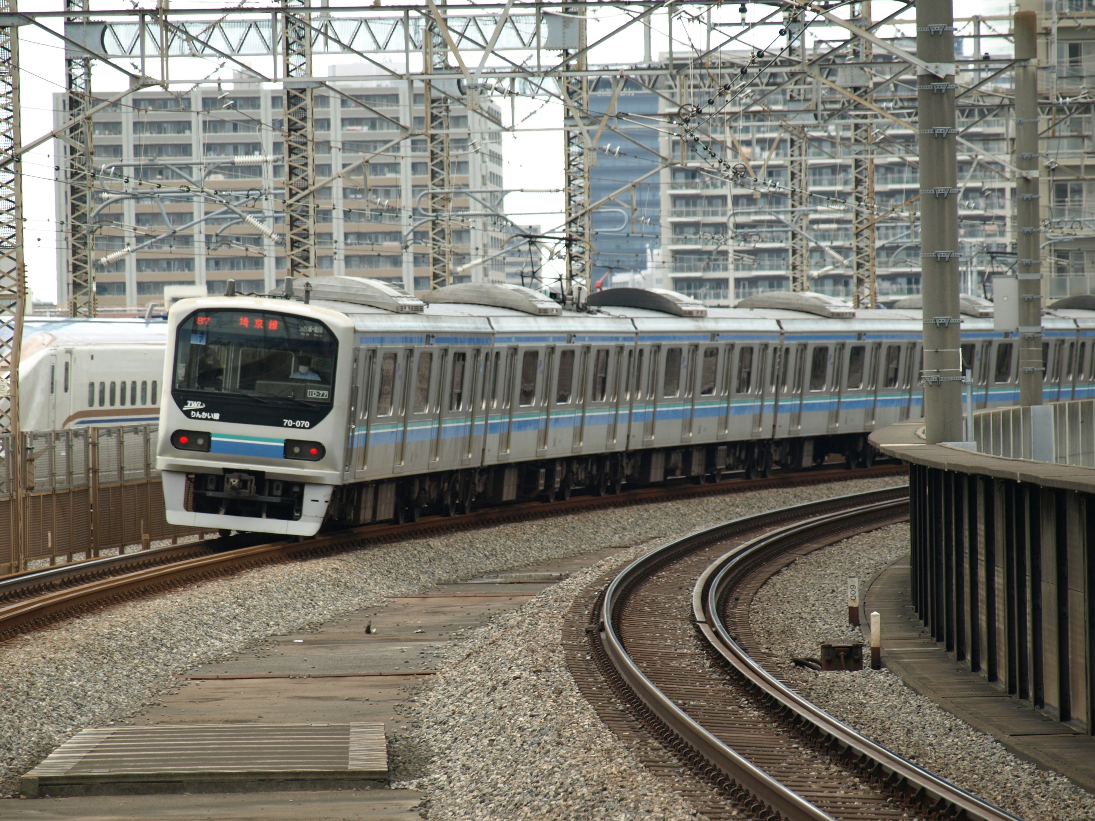 Train on curved tracks with high-rise buildings in the background