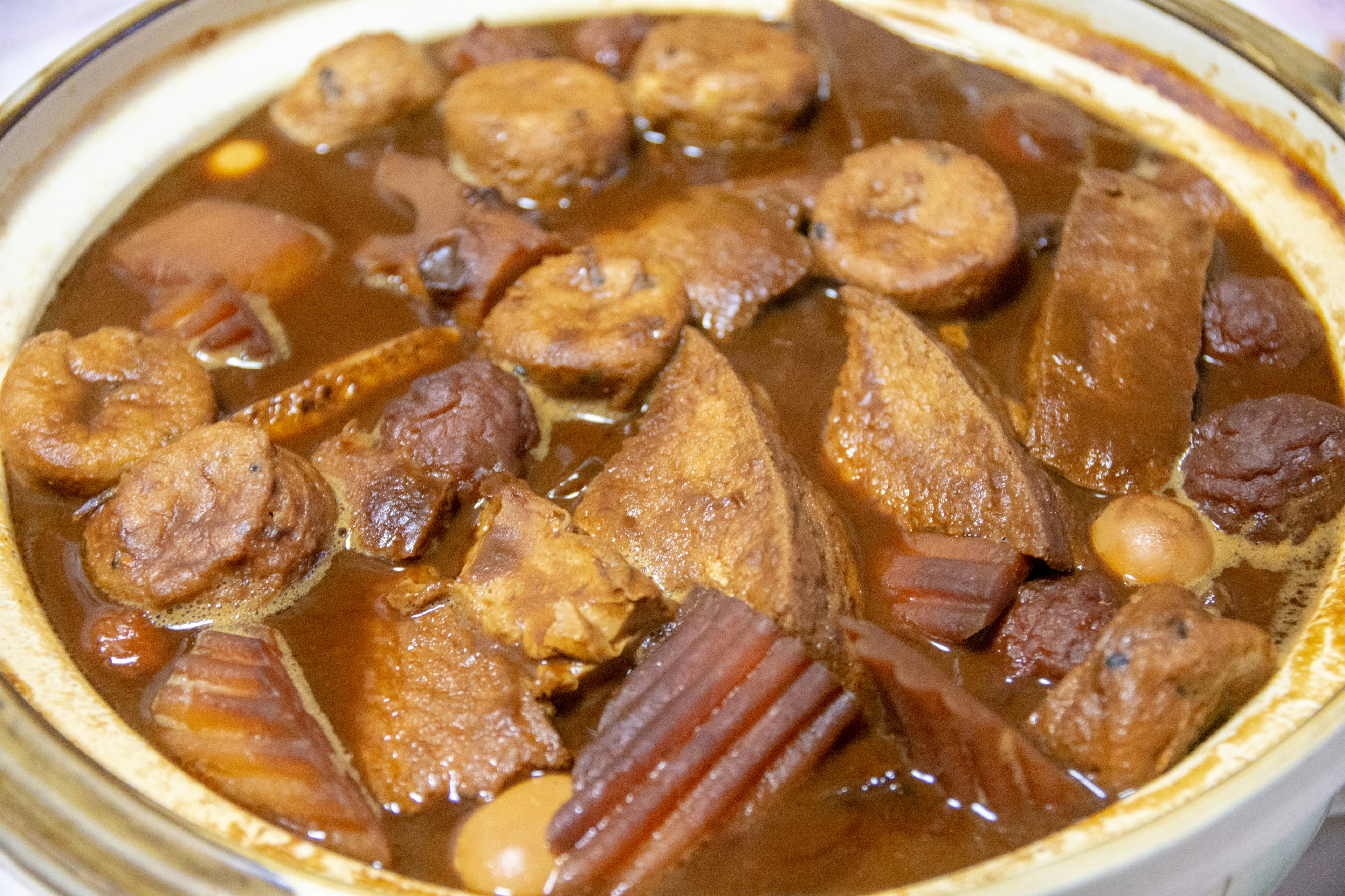 Una olla de barro llena de estofado de carne y plátano