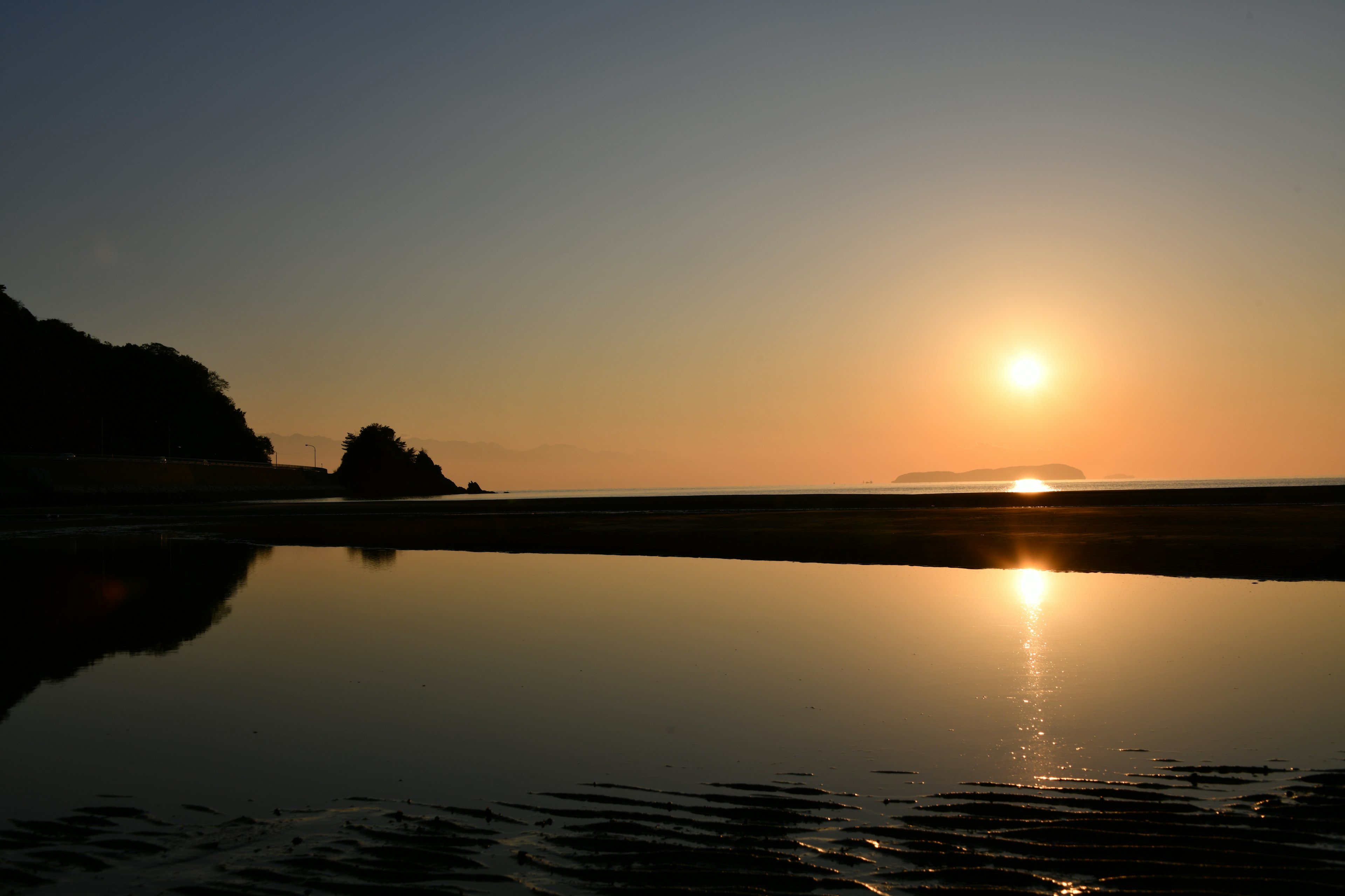 Magnifique paysage maritime avec le coucher de soleil se reflétant sur l'eau