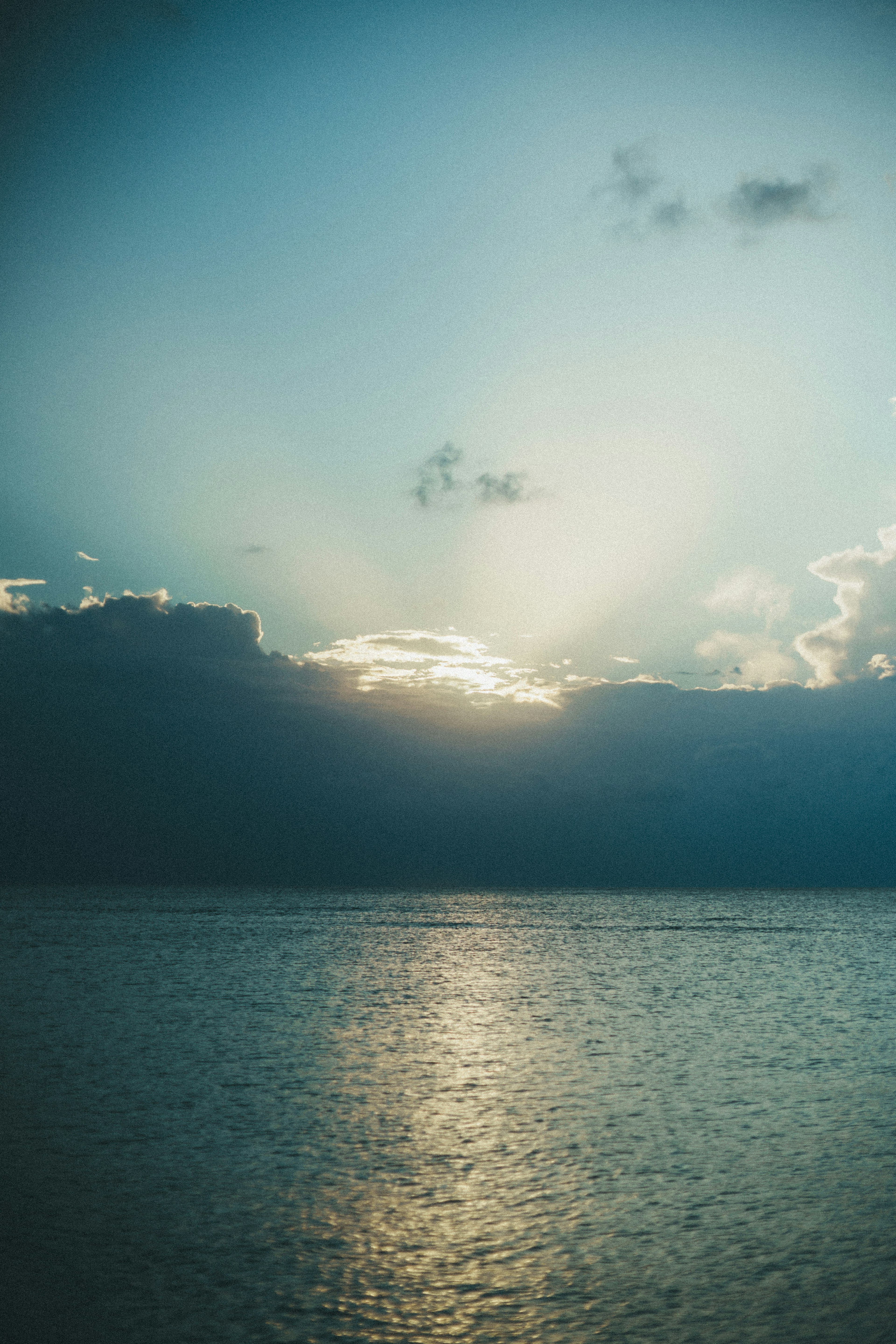 Mare calmo con un tramonto e cielo blu