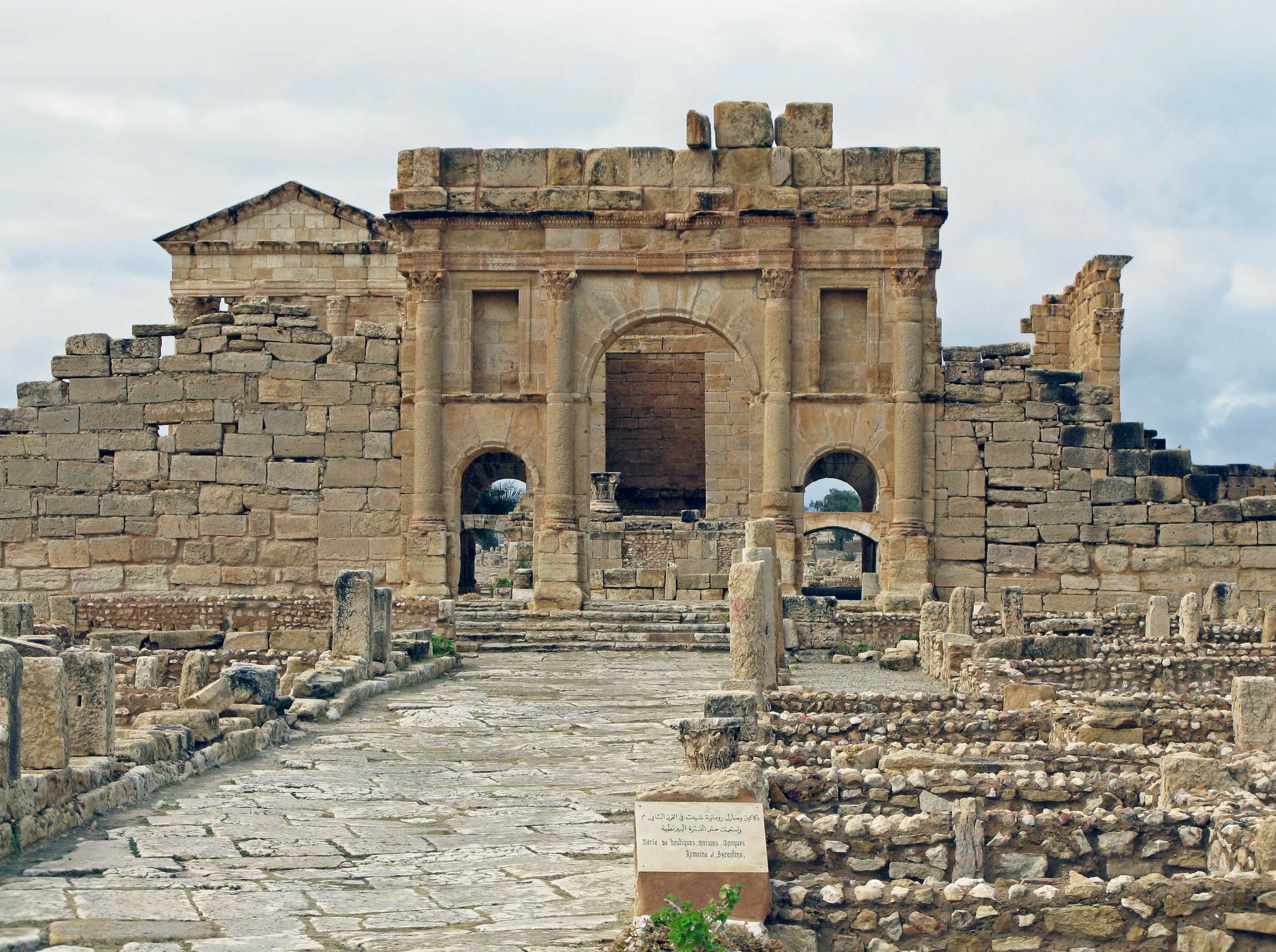 Ruinas antiguas con un arco de piedra y un camino