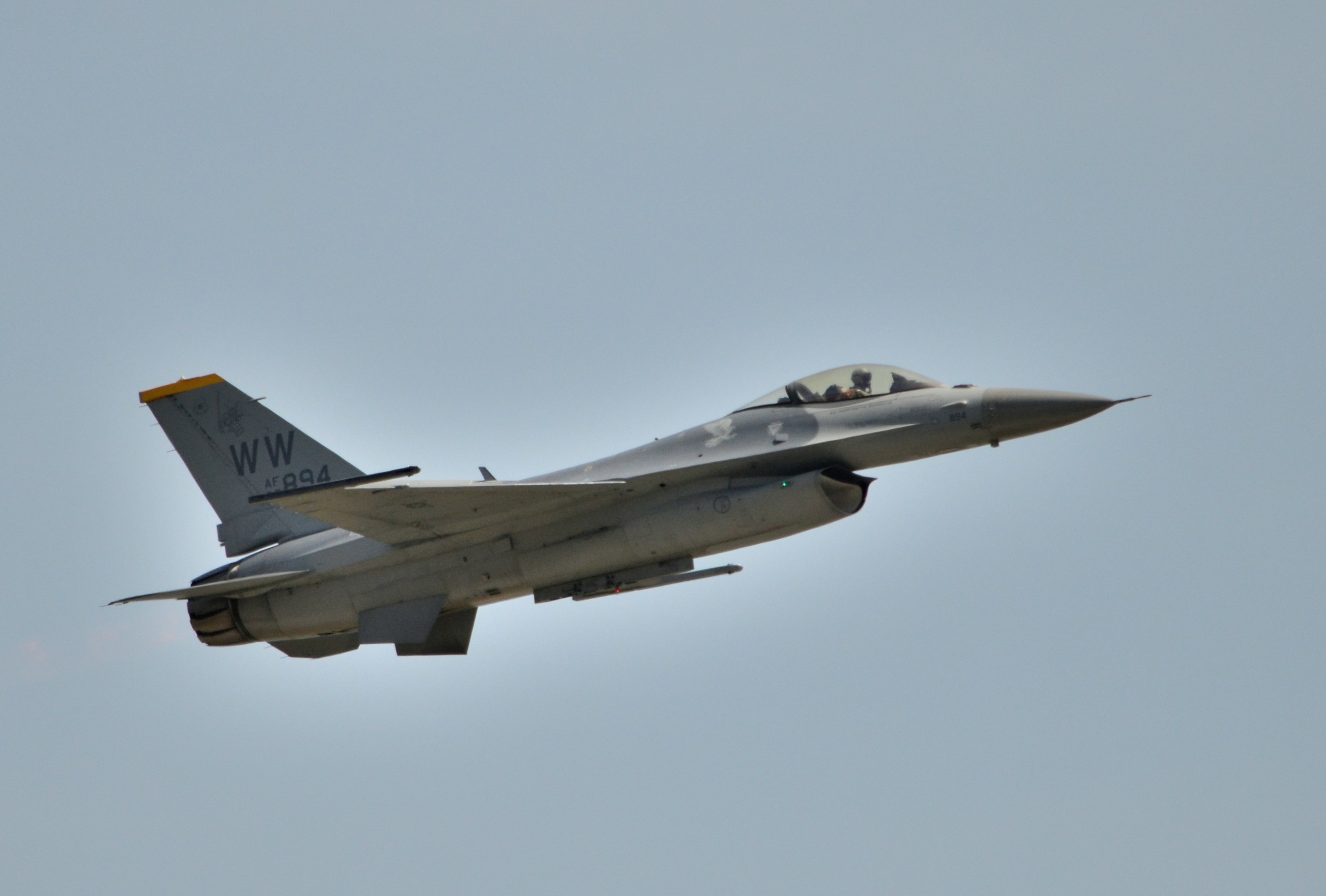 戦闘機が空を飛んでいる様子 青い空と白い雲の背景