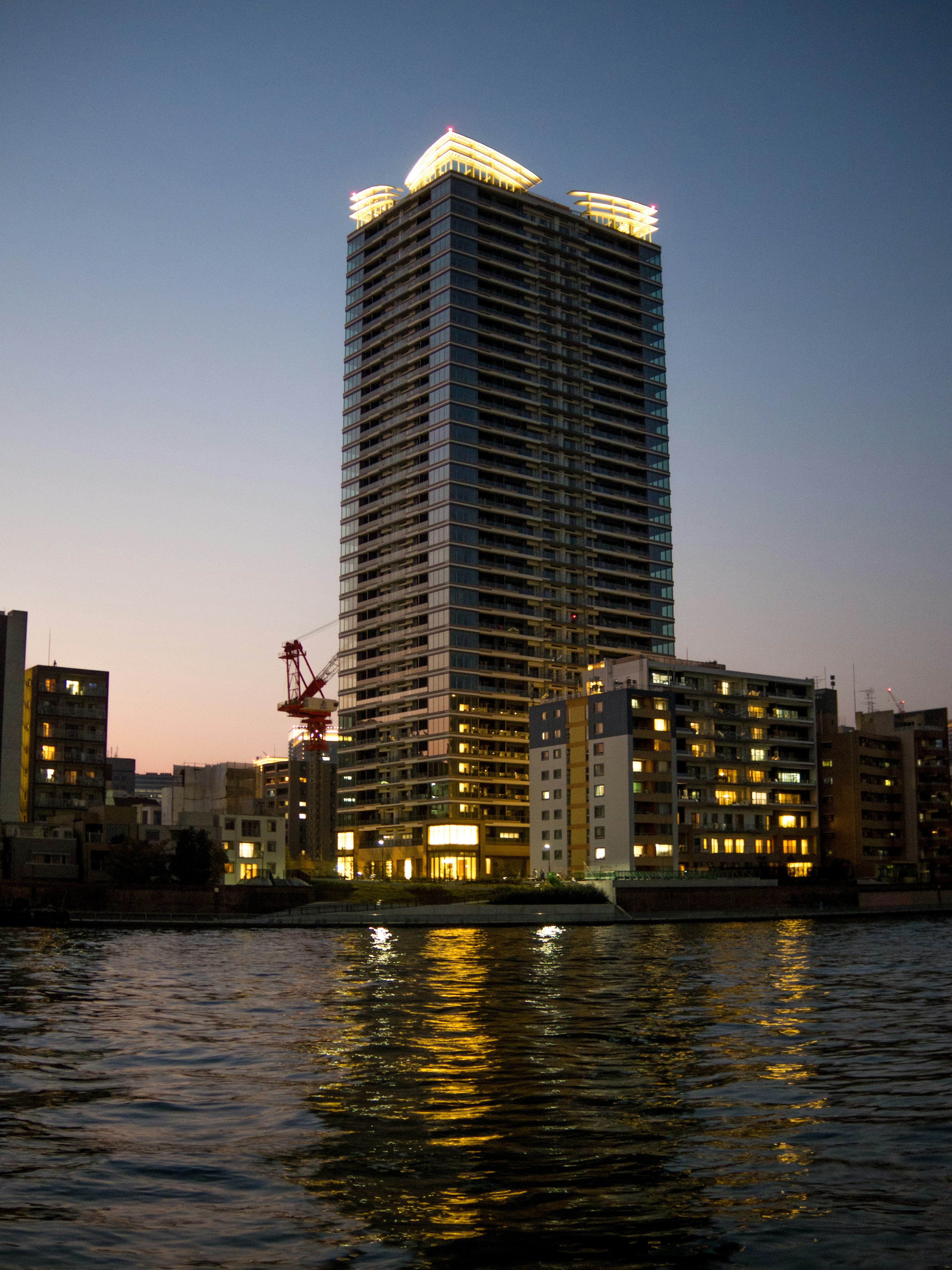 High-rise building at dusk with reflections in the water