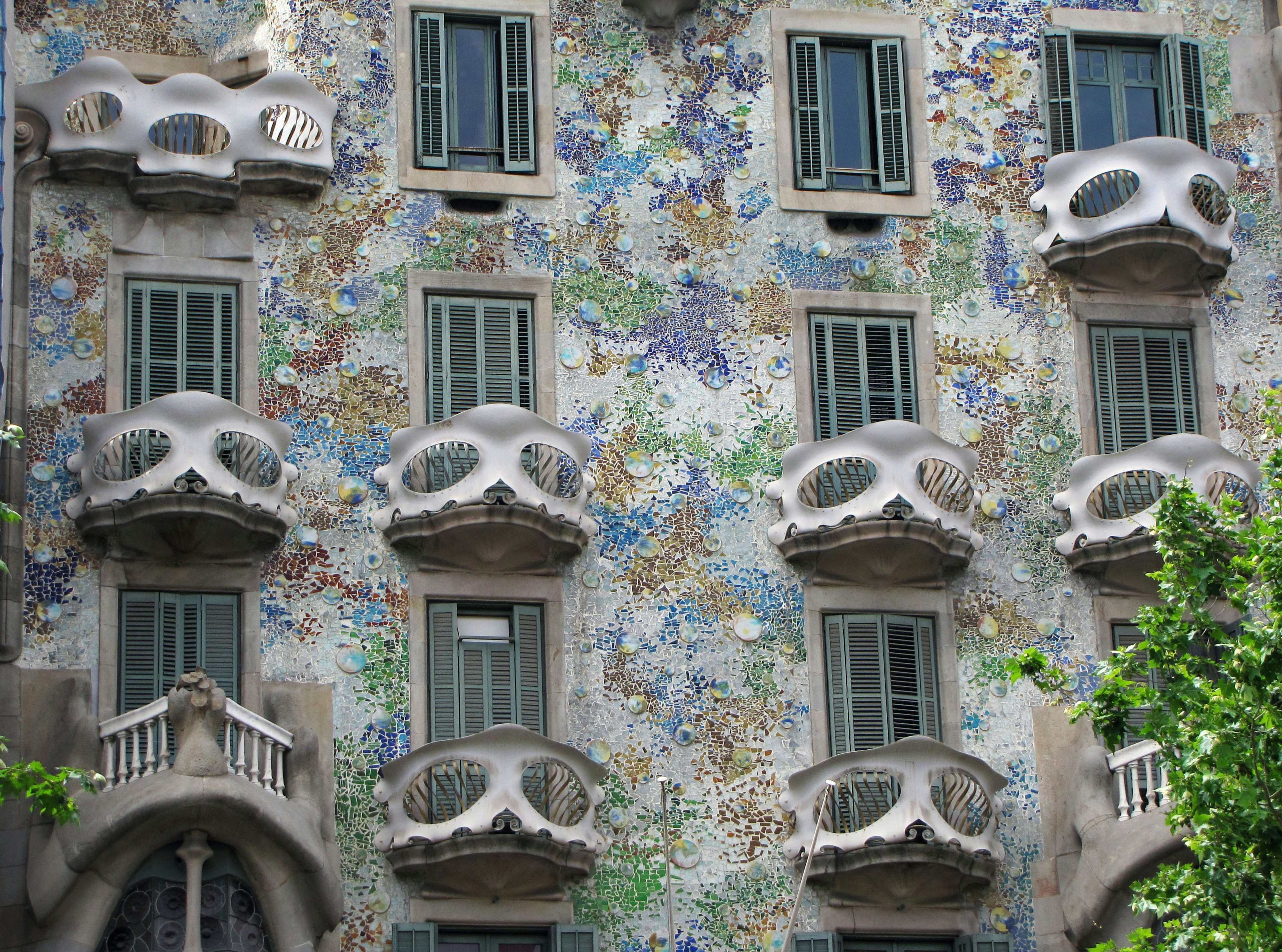 Fasad Casa Batlló di Barcelona dengan ubin berwarna-warni dan balkon unik