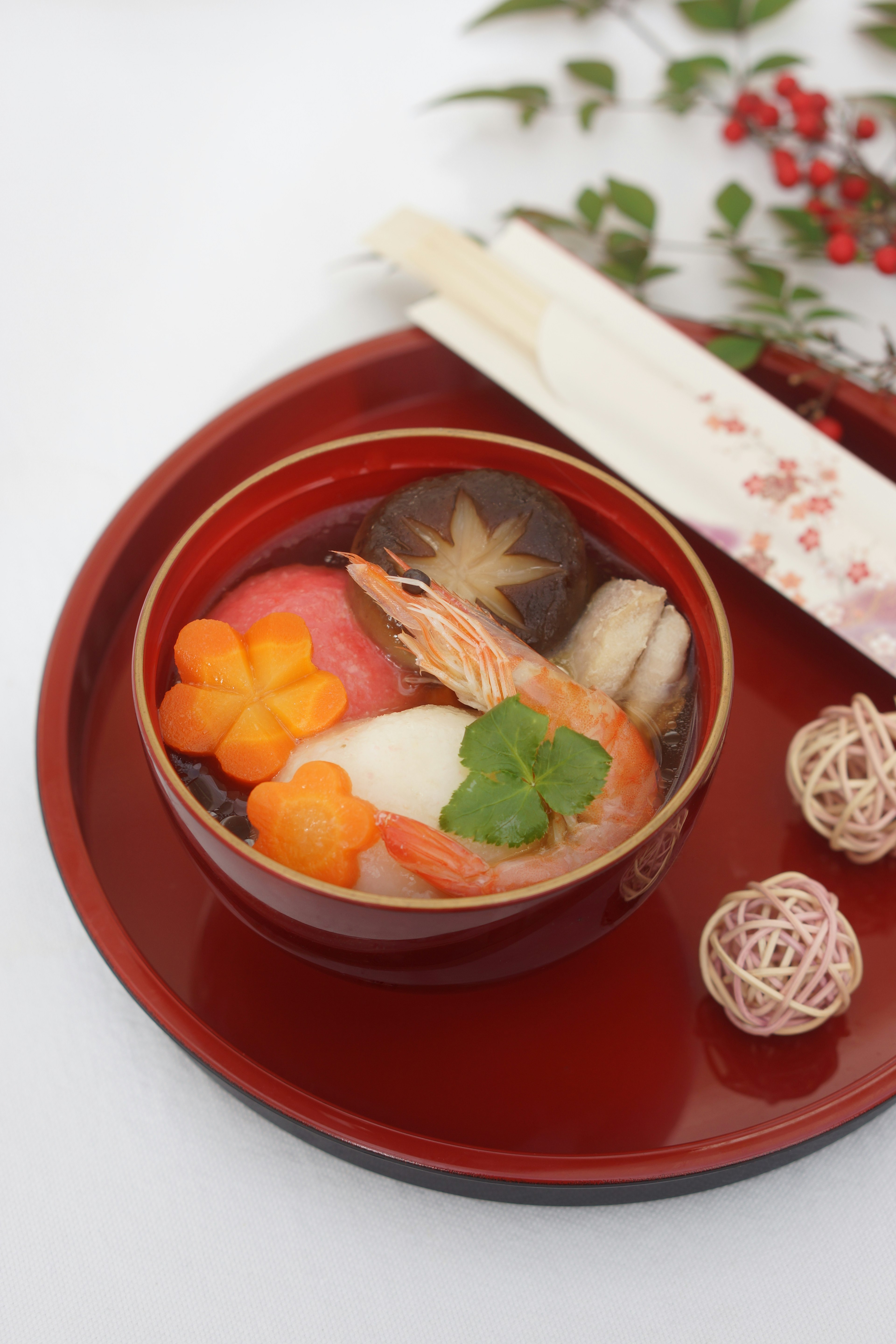 A beautifully presented bowl of Japanese soup featuring colorful ingredients and shrimp slices