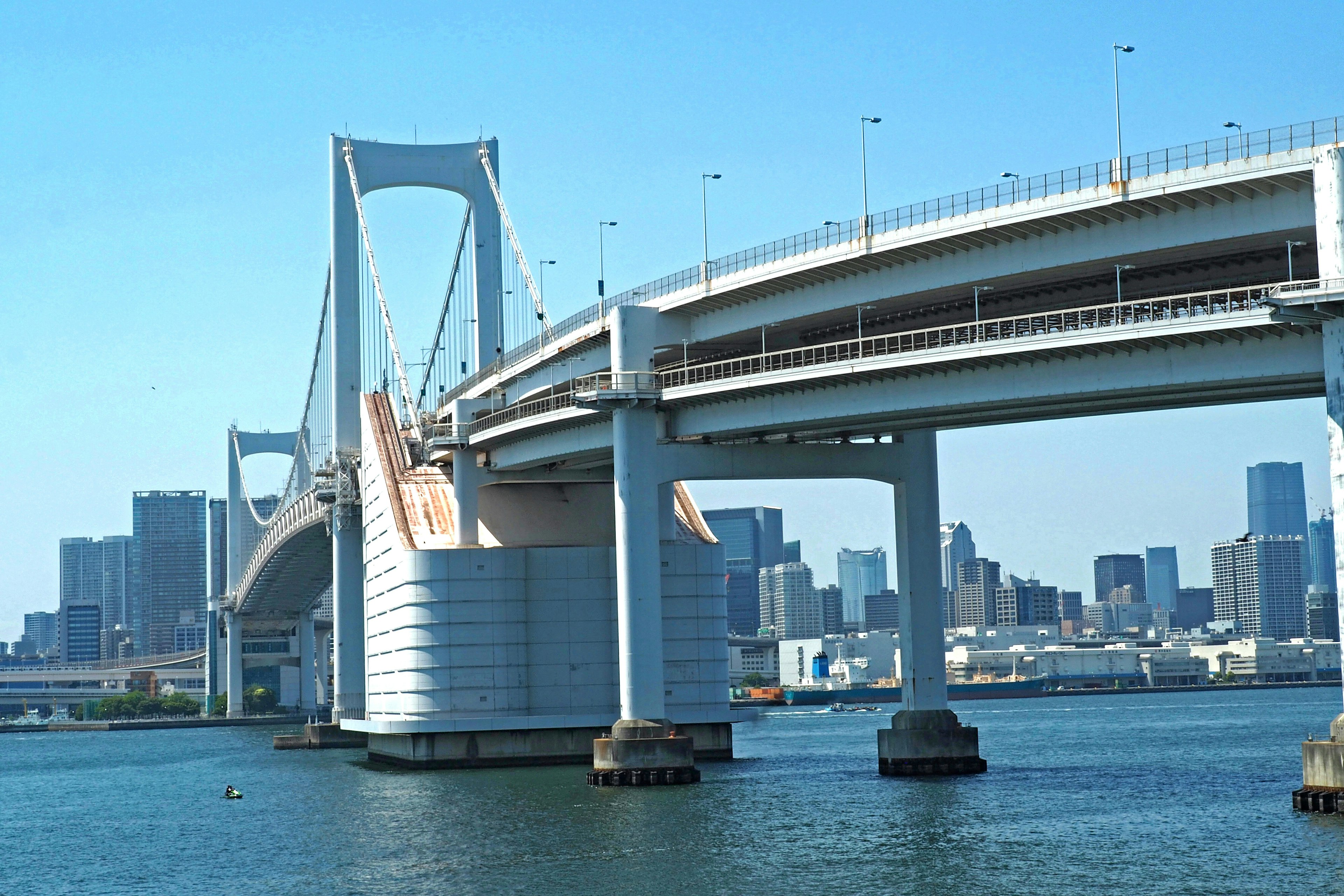 Struktur der Rainbow Bridge mit urbaner Skyline im Hintergrund