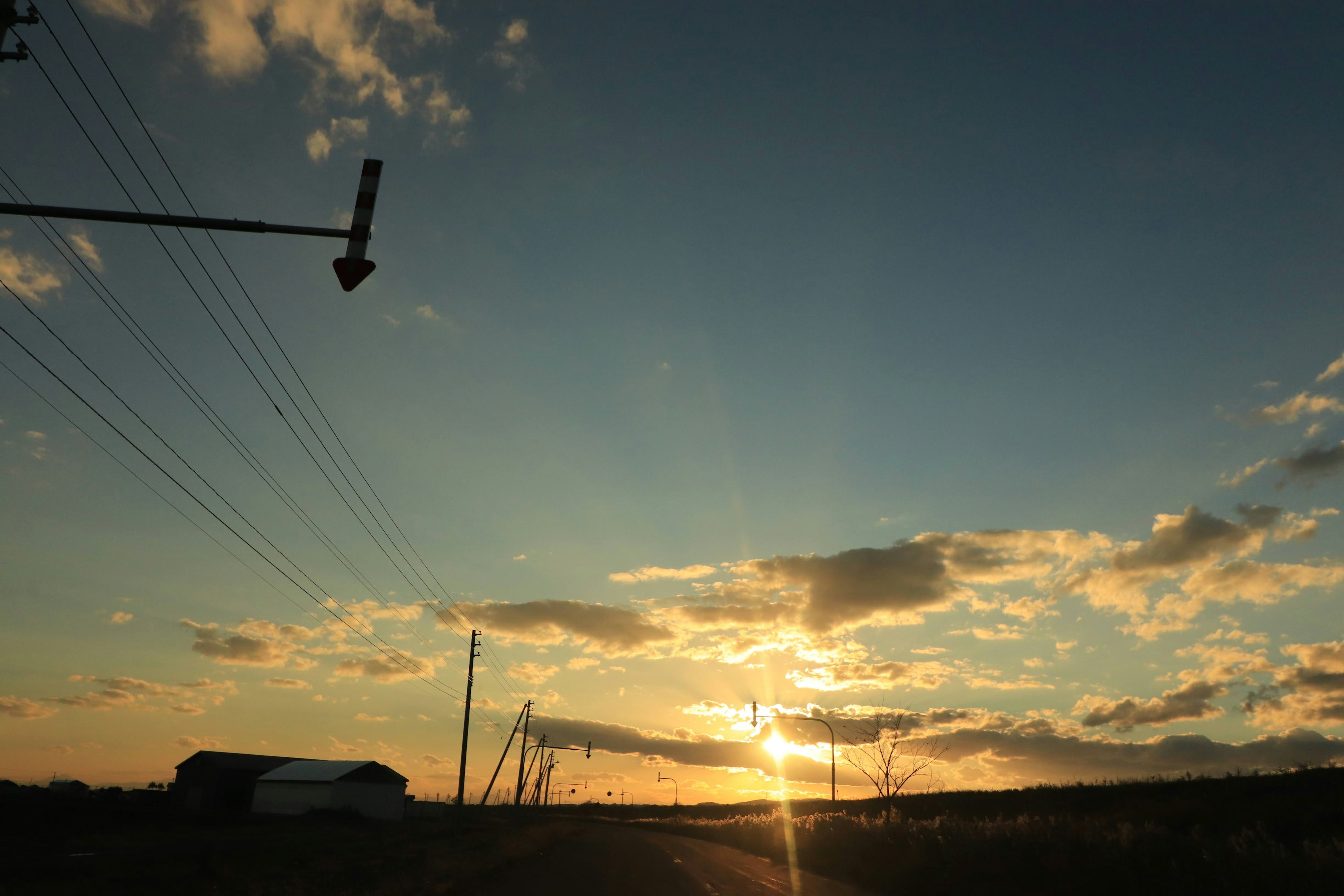 Vue pittoresque du coucher de soleil avec des nuages et des lignes électriques