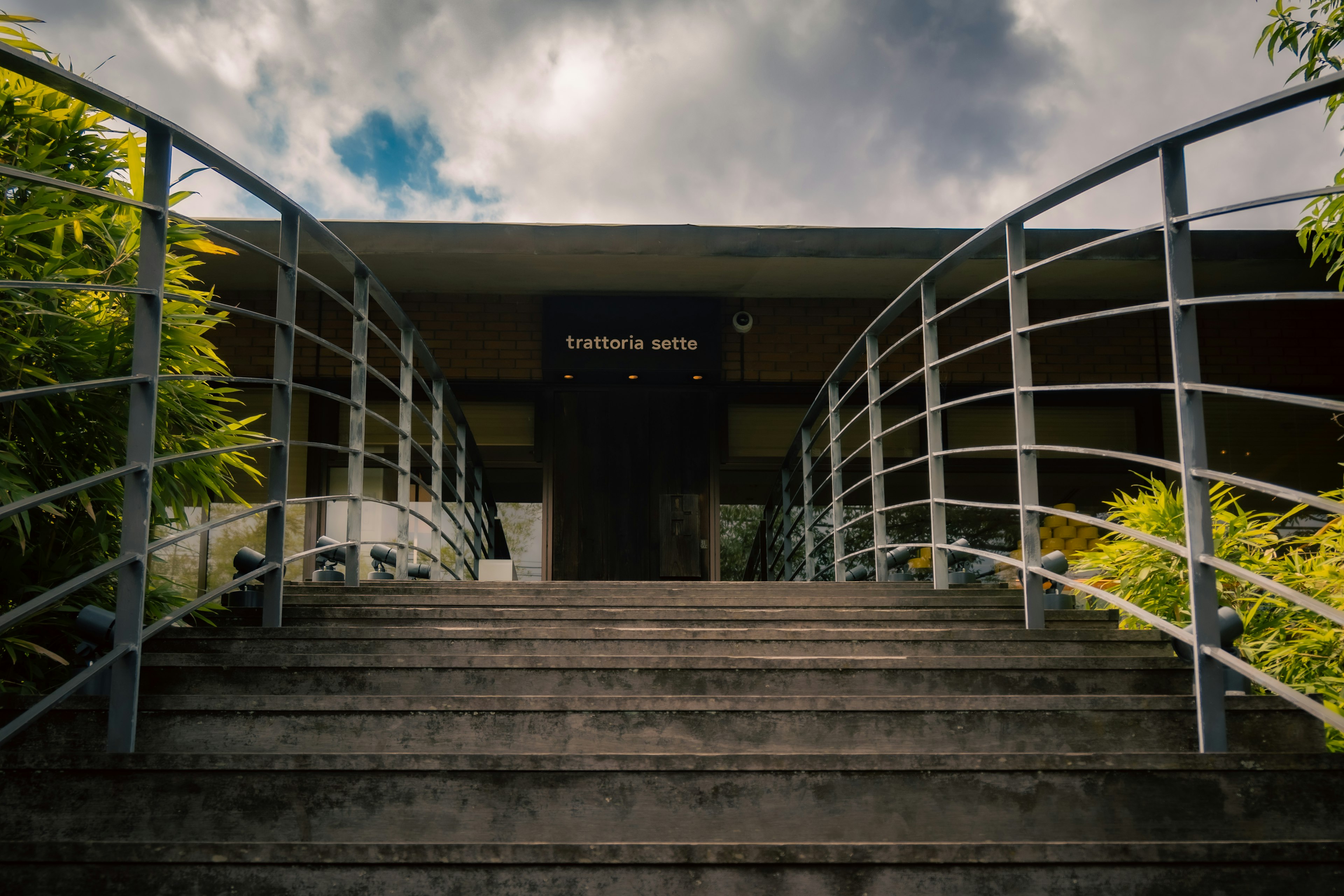 Entrée d'un bâtiment avec des escaliers et des rampes