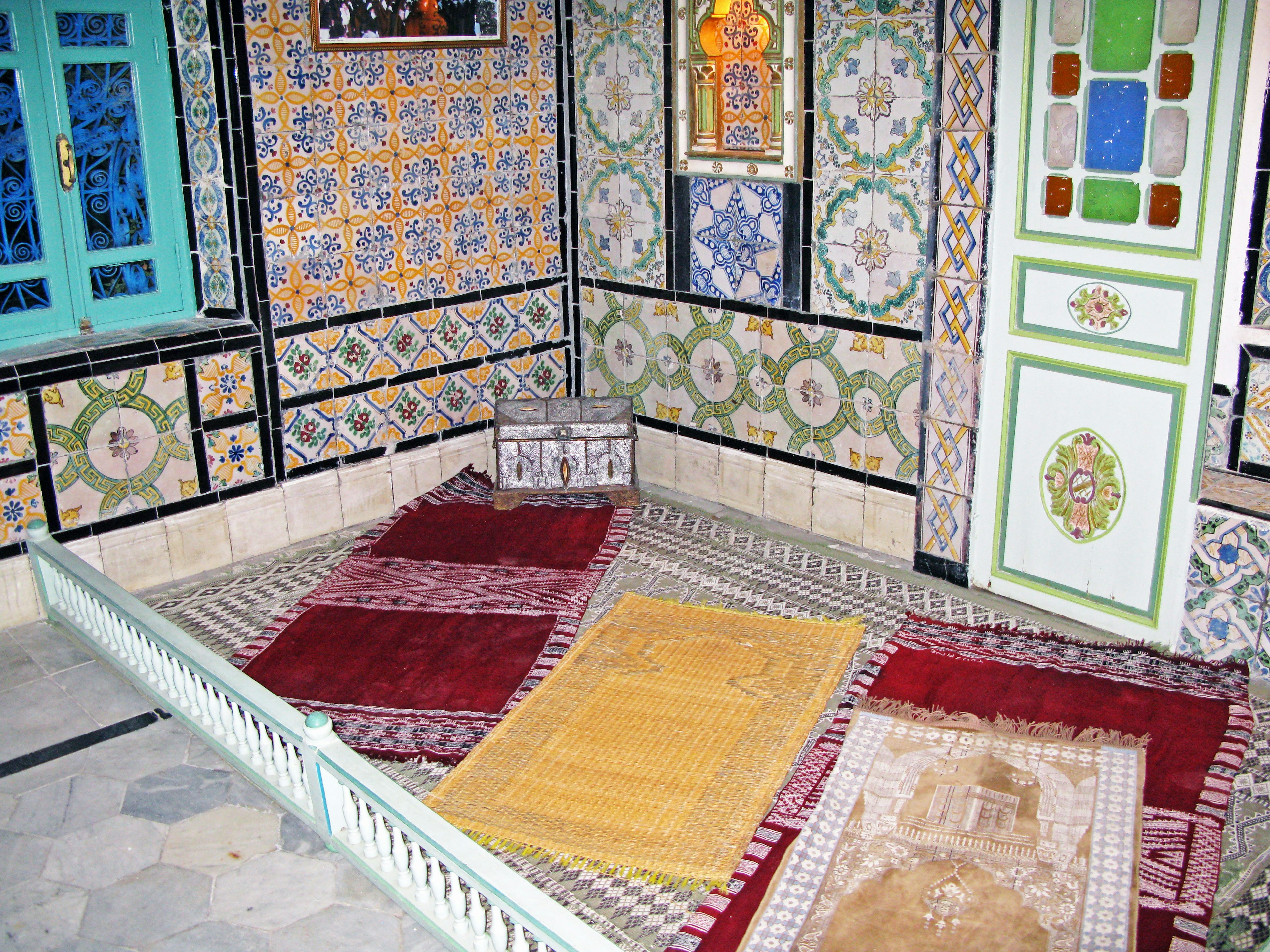 Interior of a traditional room with decorative tiles and vibrant carpets