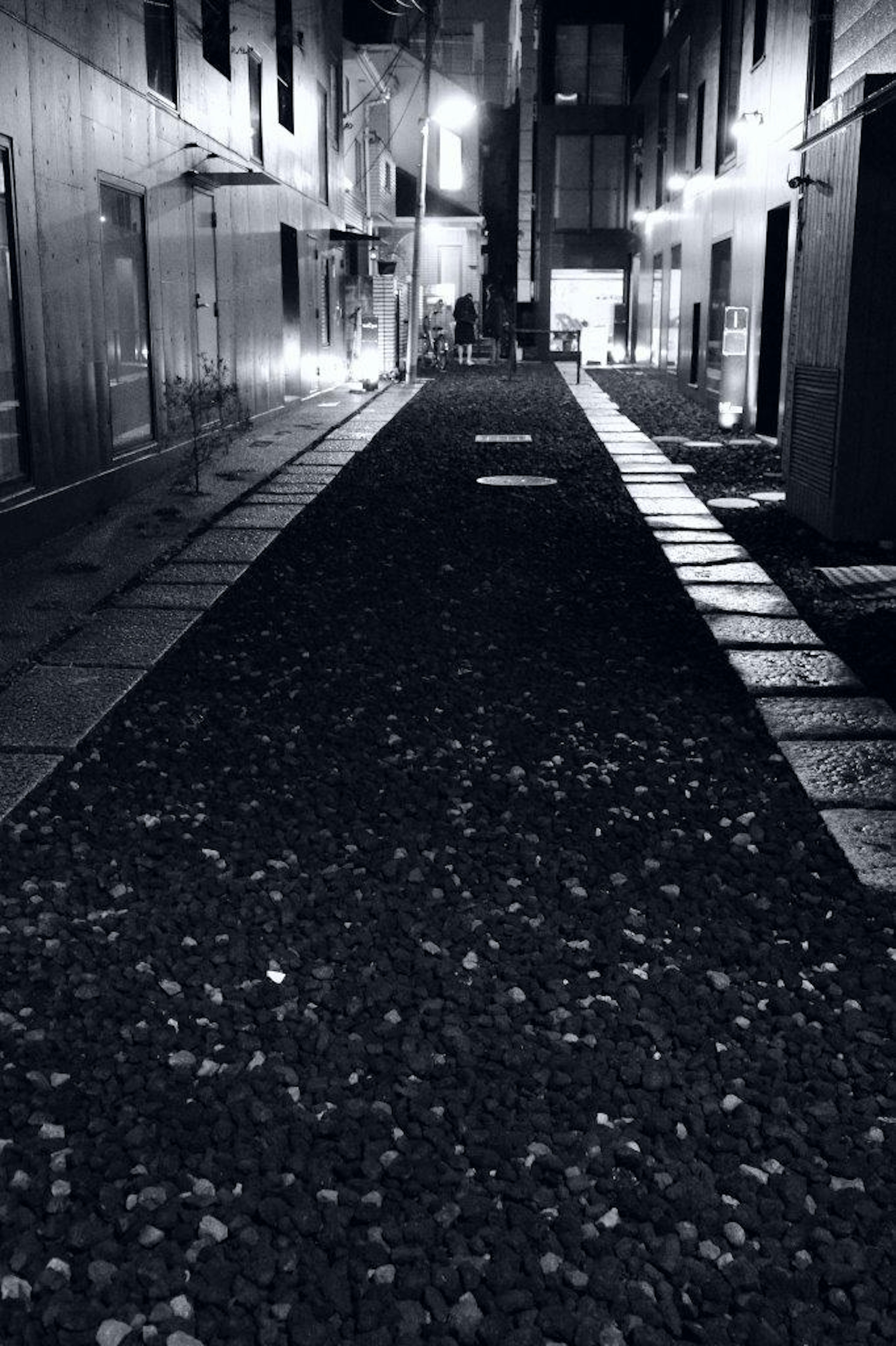 Narrow alley with a gravel path and buildings on either side