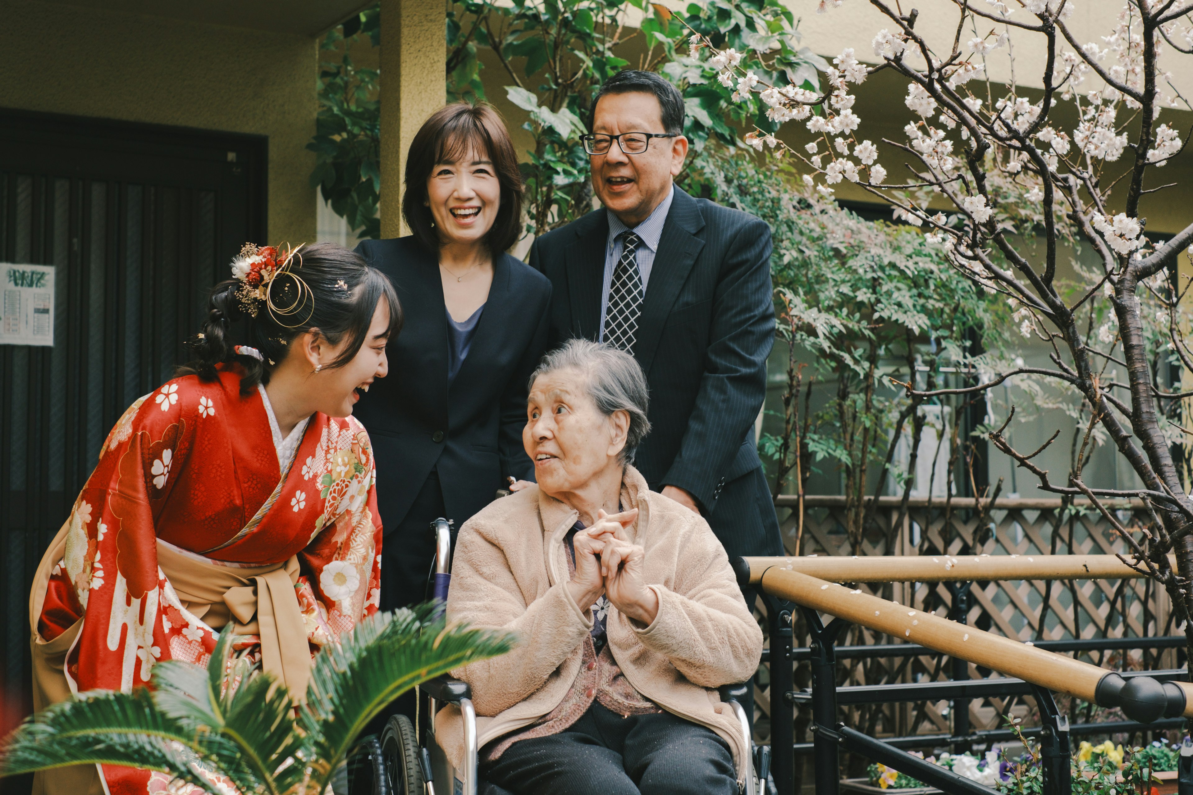 A family gathered together smiling in a garden setting