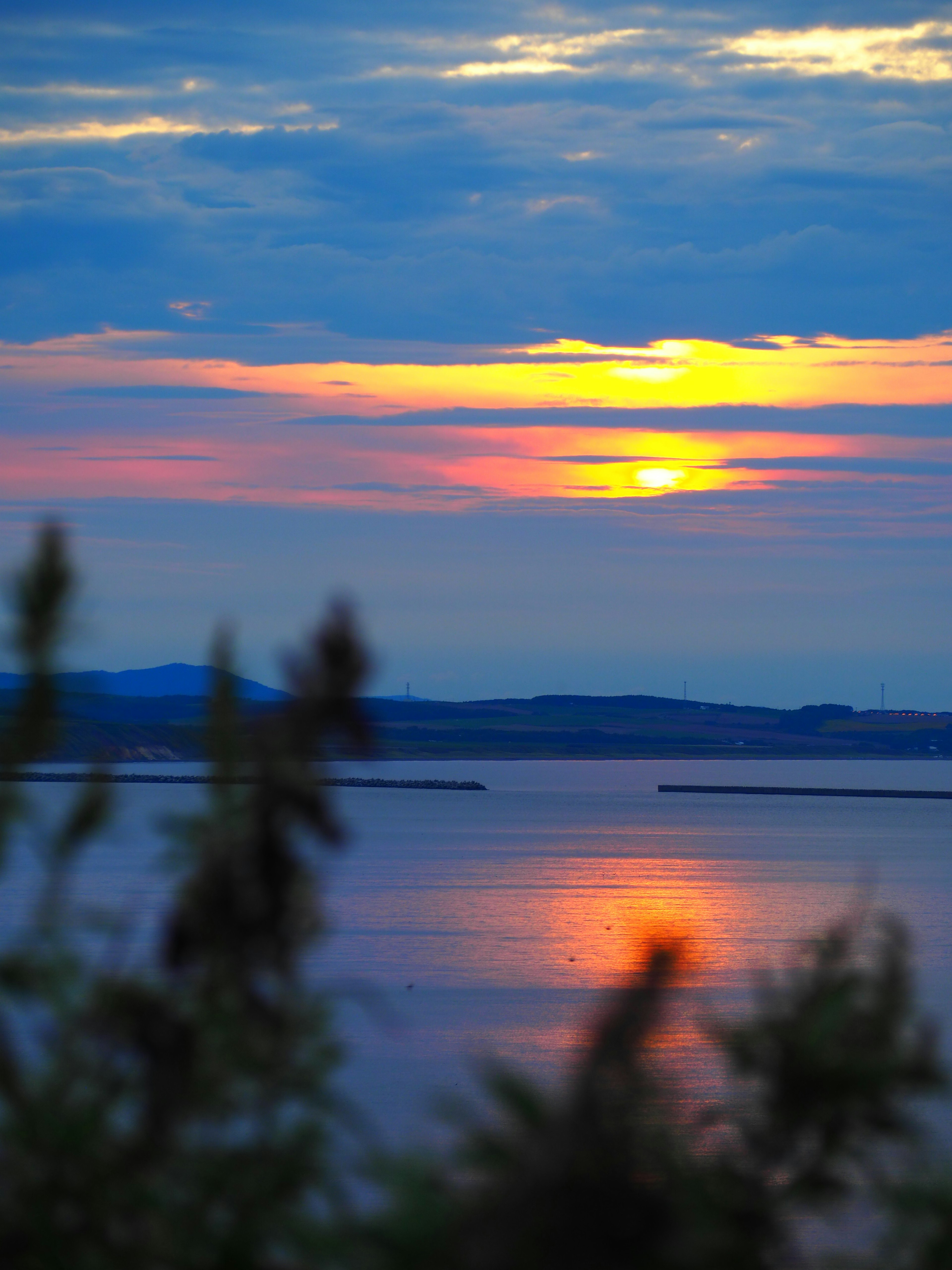 Vista panoramica di un cielo blu e di un tramonto arancione che si riflette sull'acqua