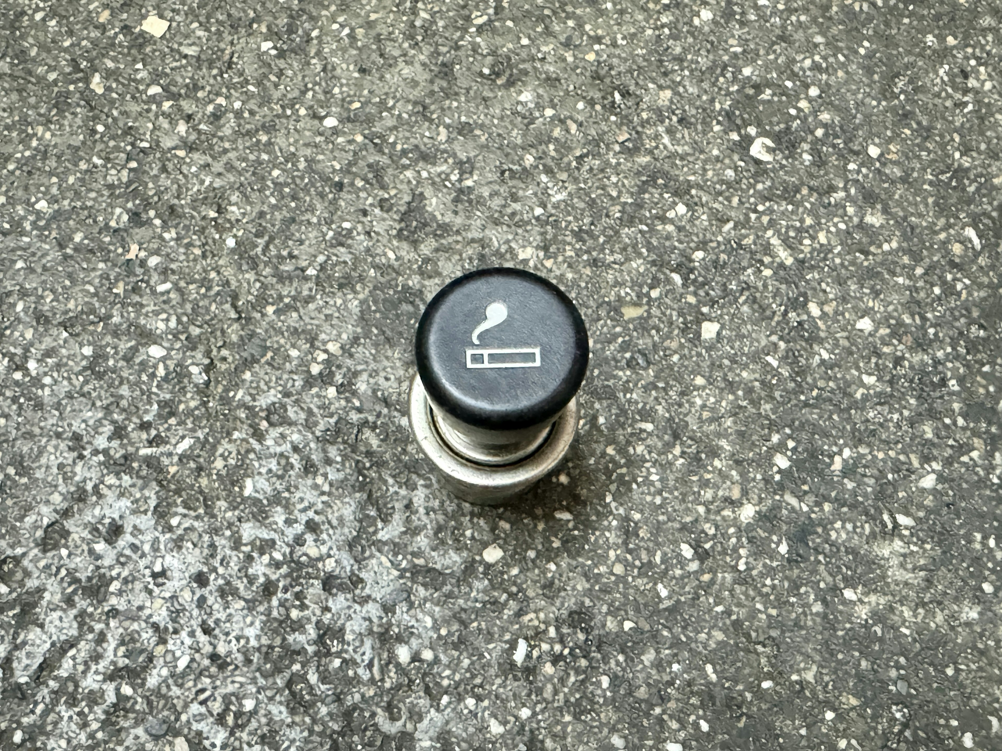 Black smoking button placed on a gray surface