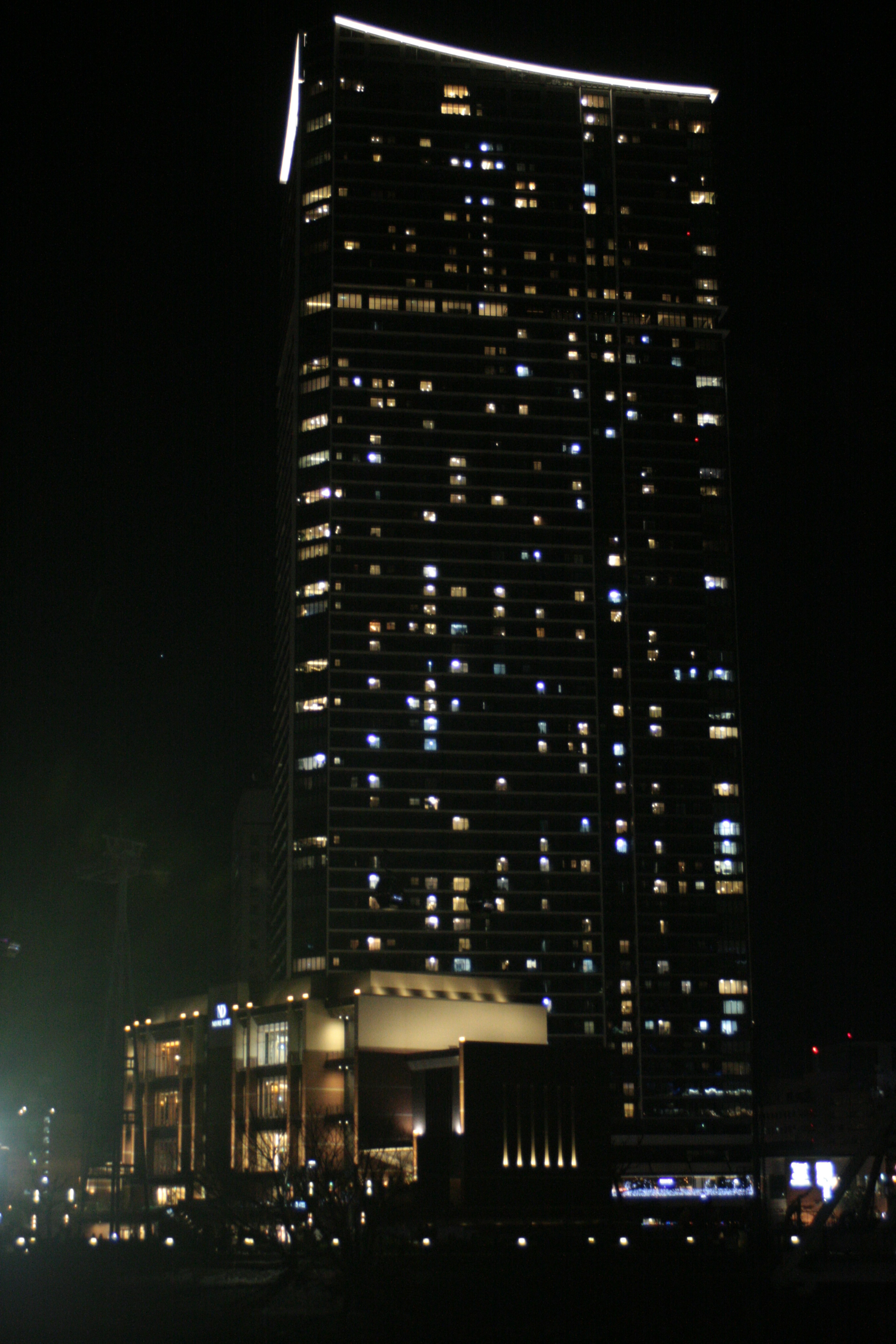 Rascacielos iluminado en una ciudad de noche mostrando luces vibrantes