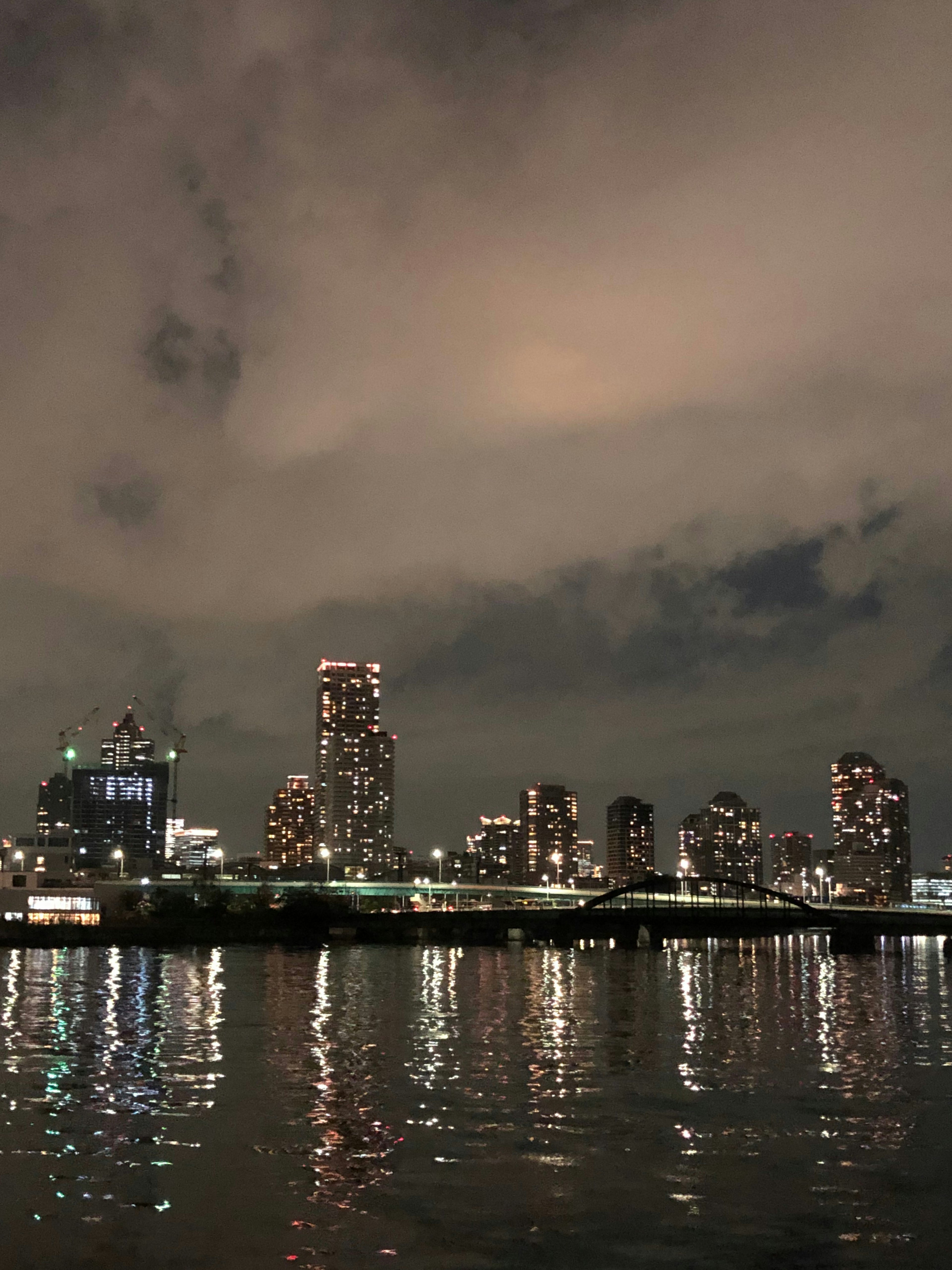 Nachtsilhouette der Stadt mit Reflexionen im Wasser