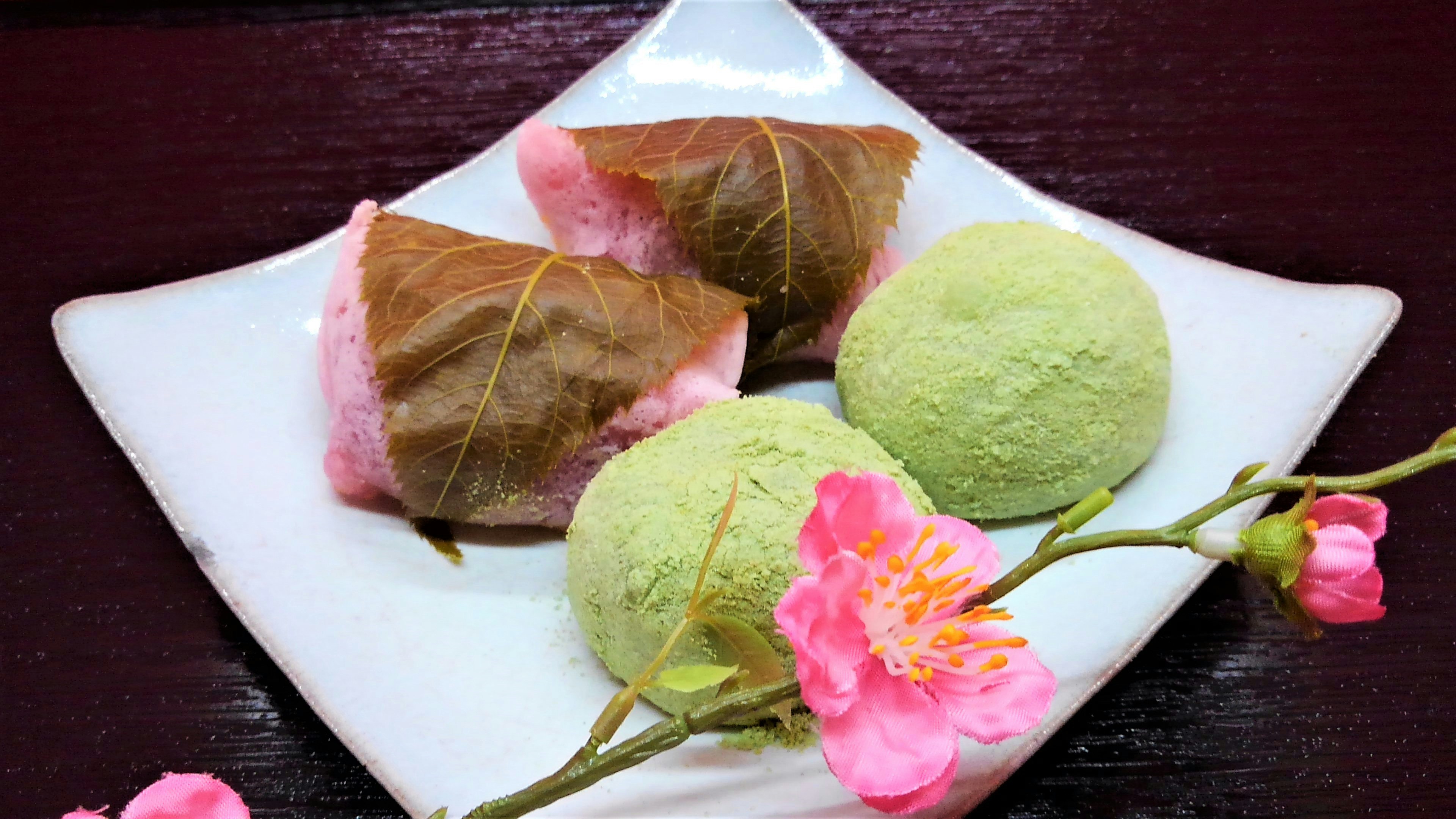 Susunan manisan Jepang musim semi dengan makanan yang dibungkus daun sakura dan bola matcha