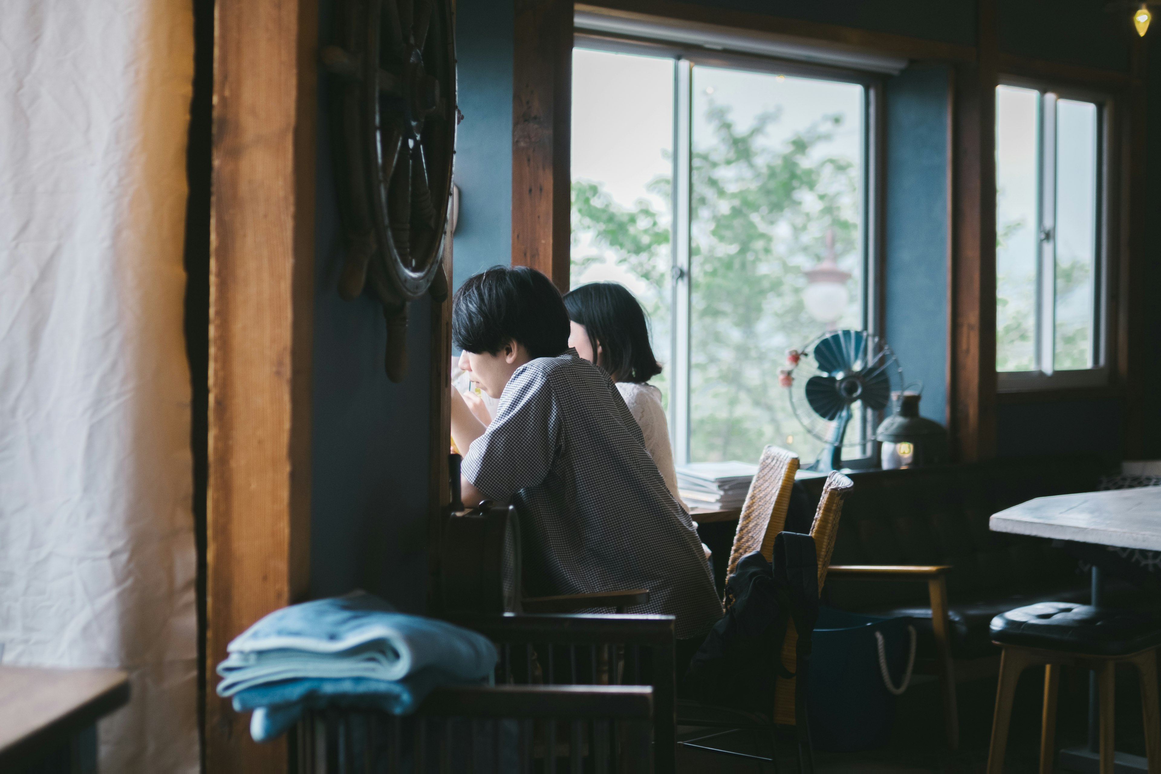 Two women deep in thought by the window in a cozy café setting