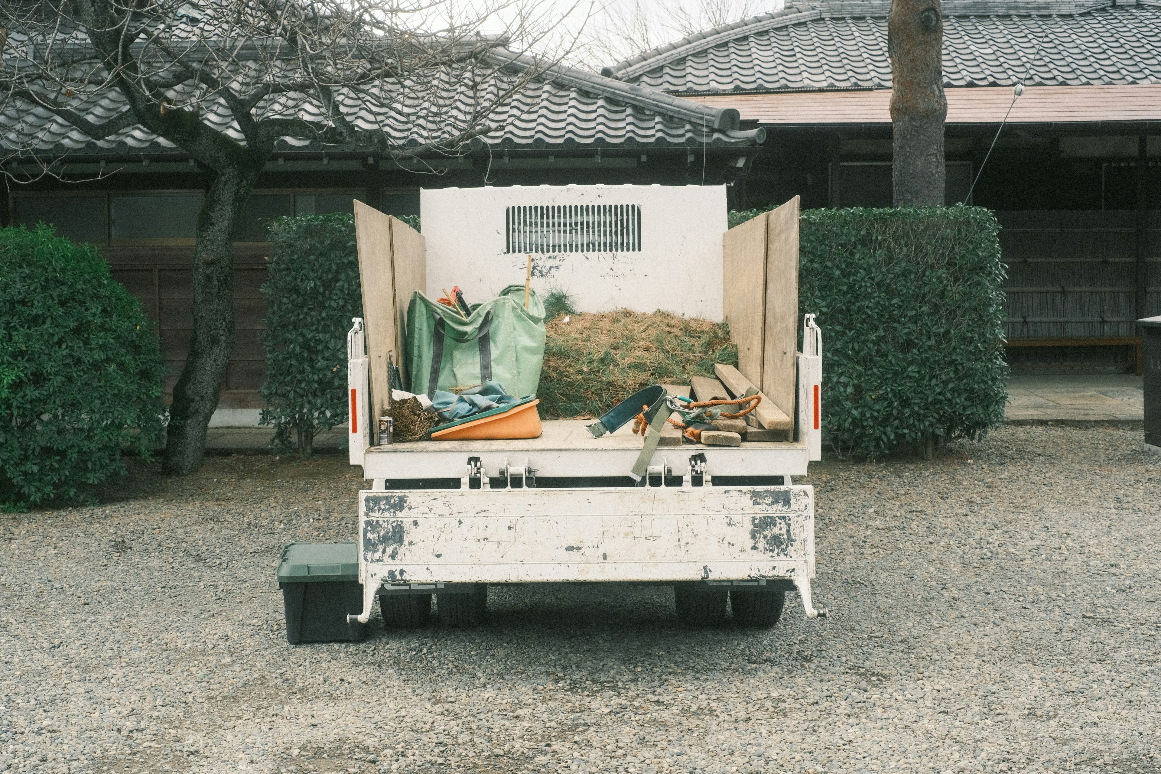 A truck bed filled with green objects and wooden tools