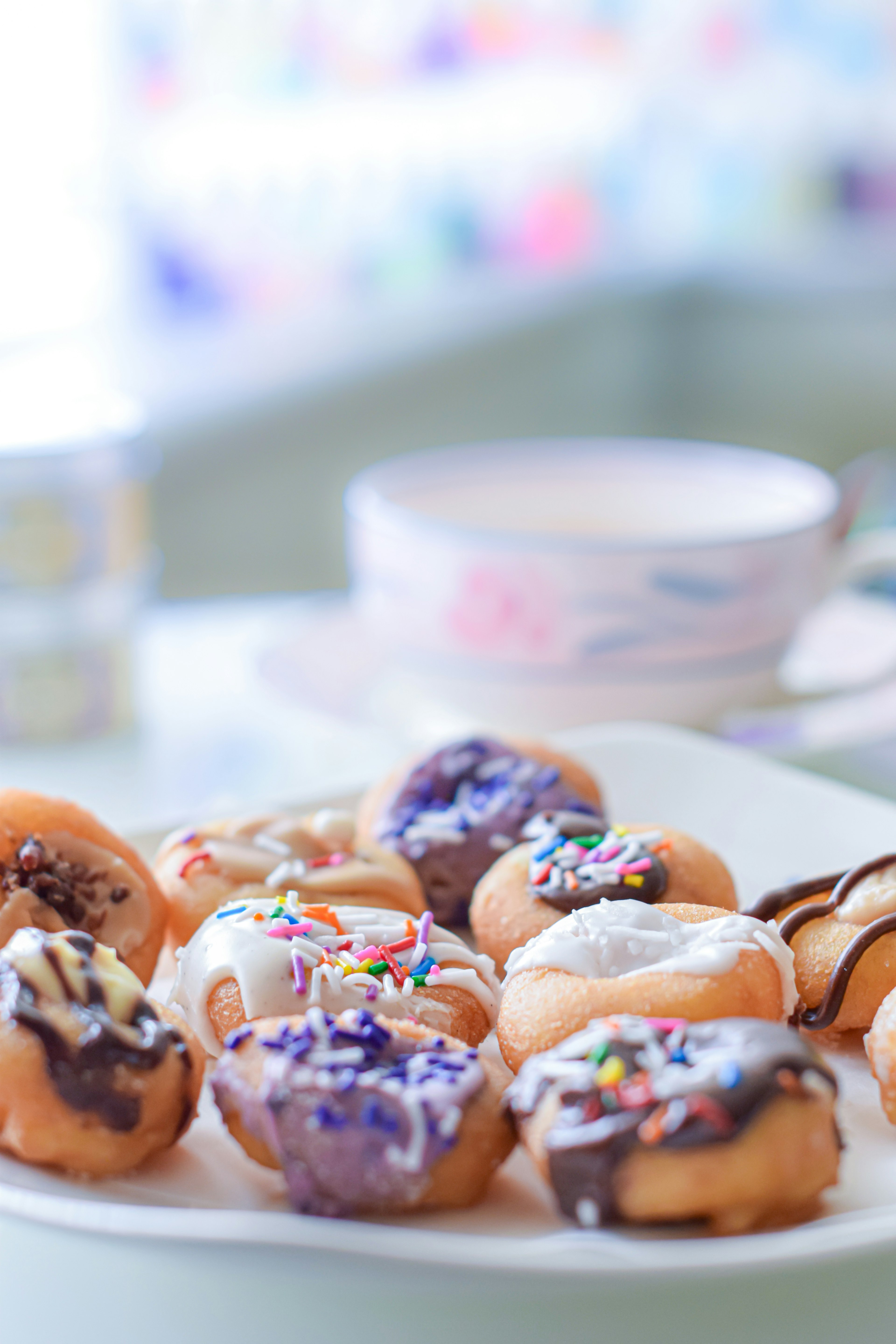 Colorful donuts with various toppings arranged on a white plate