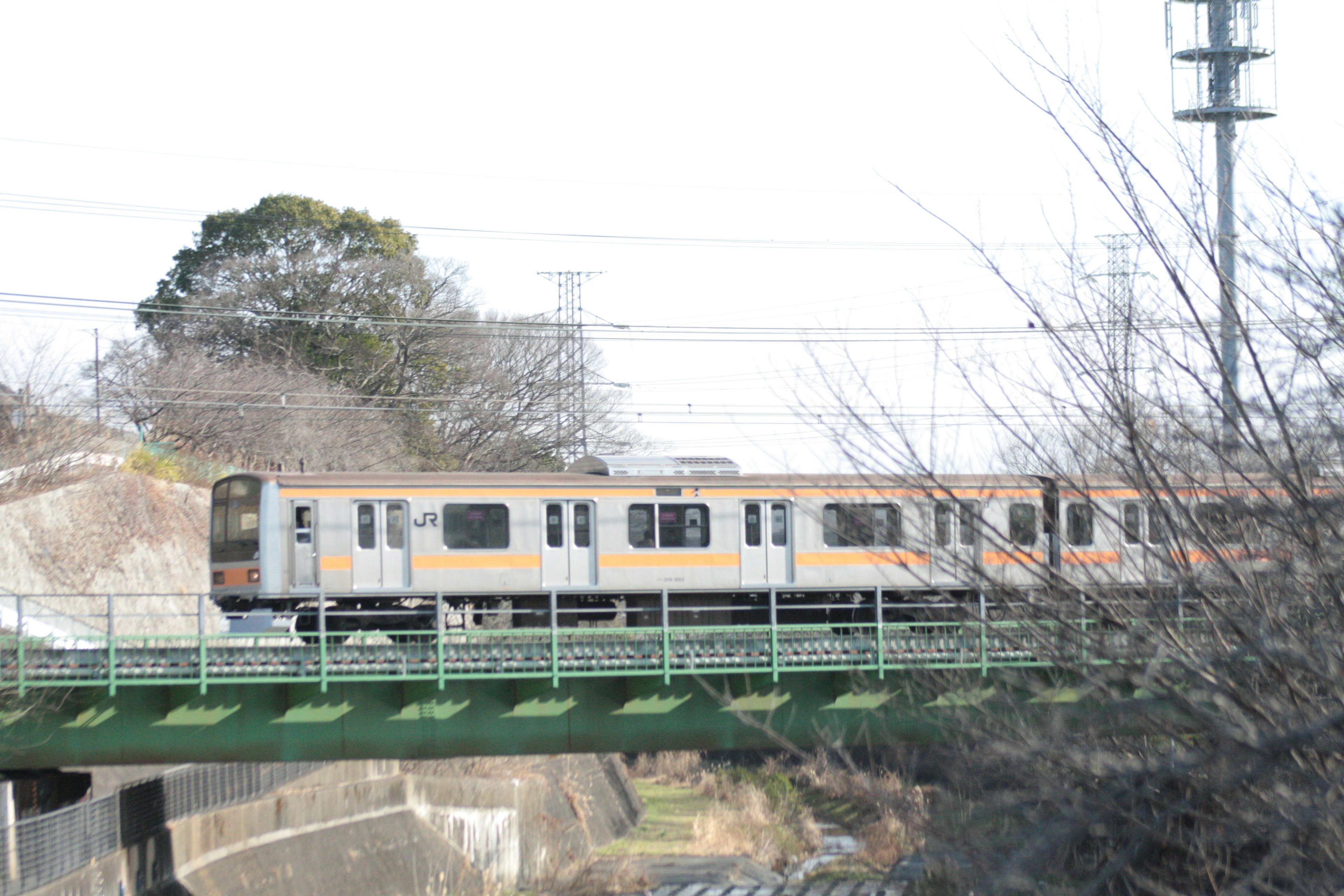 Train crossing a green bridge