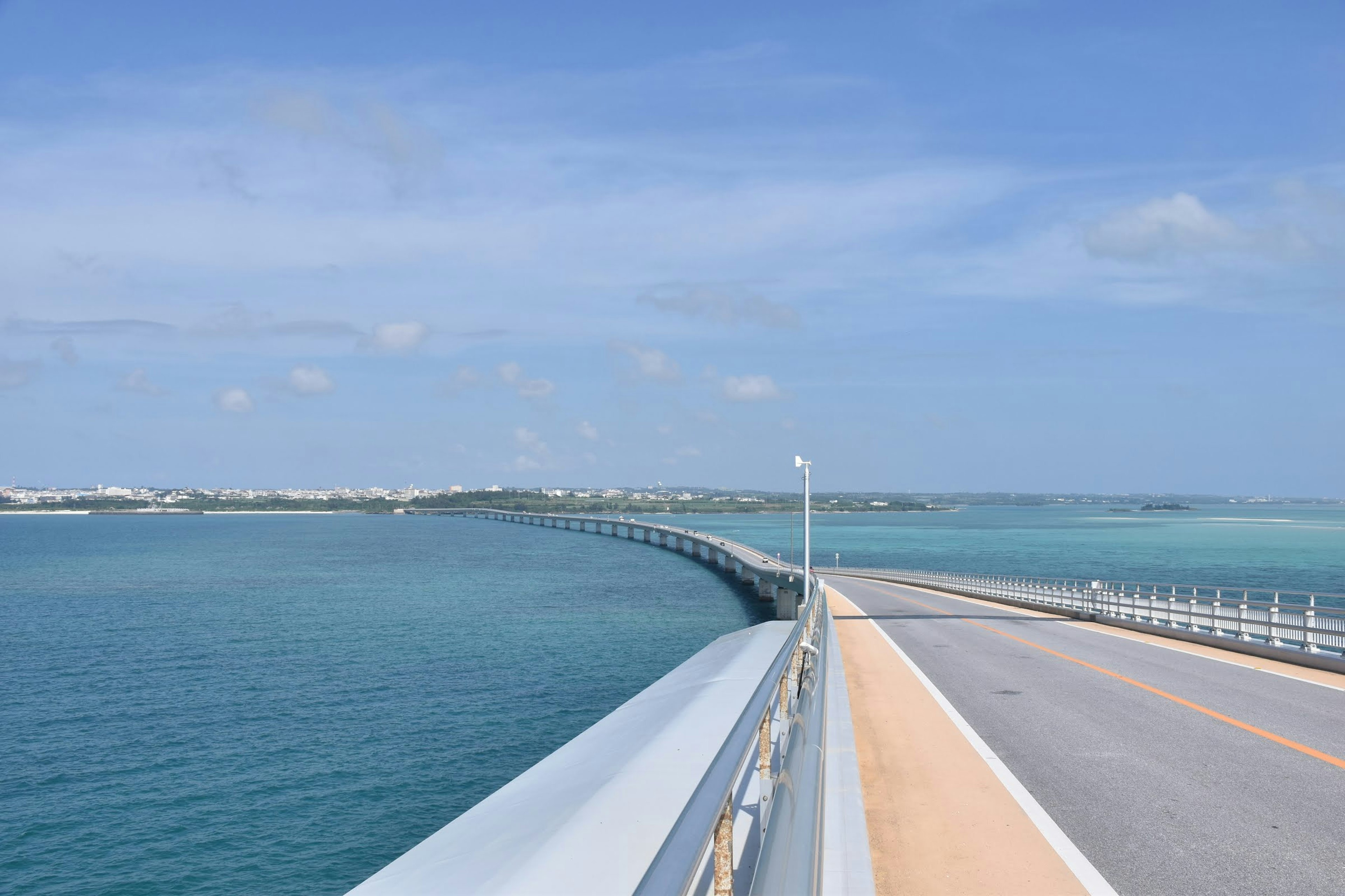 Puente curvo sobre el mar azul con cielo despejado