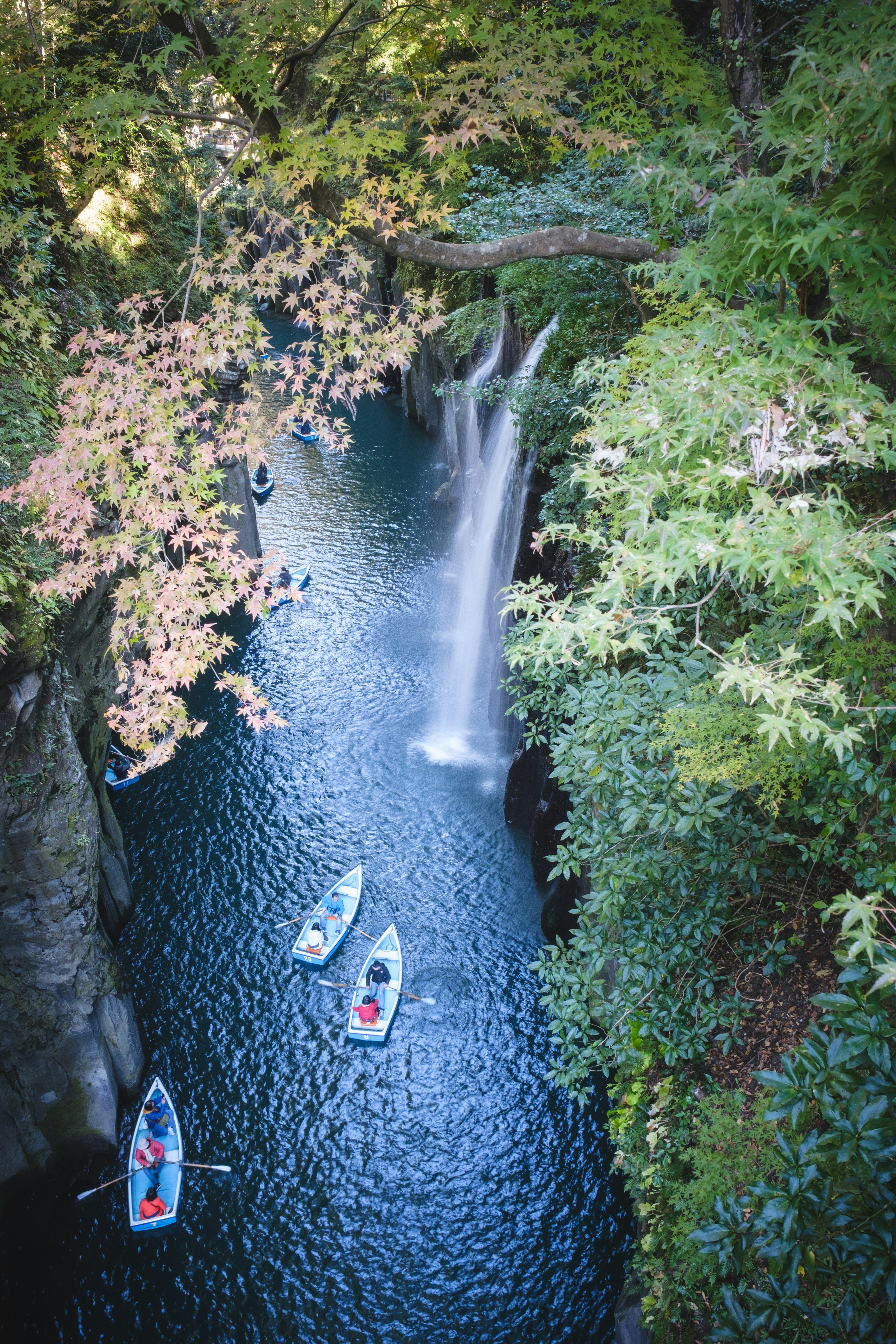 Malersiche Aussicht auf einen Wasserfall mit Kajaks in einer üppigen Schlucht