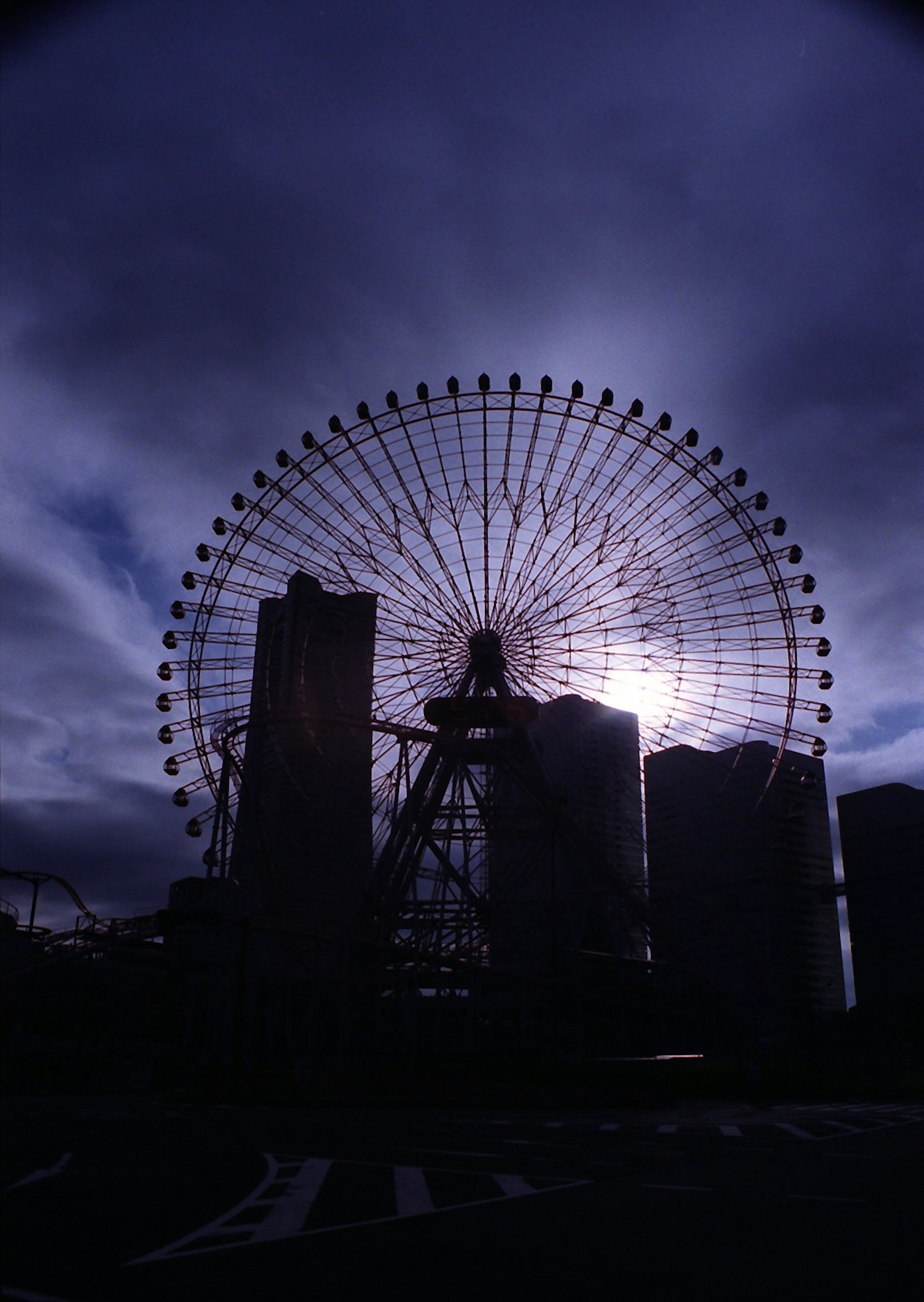 Silhouette di una ruota panoramica contro un cielo scuro