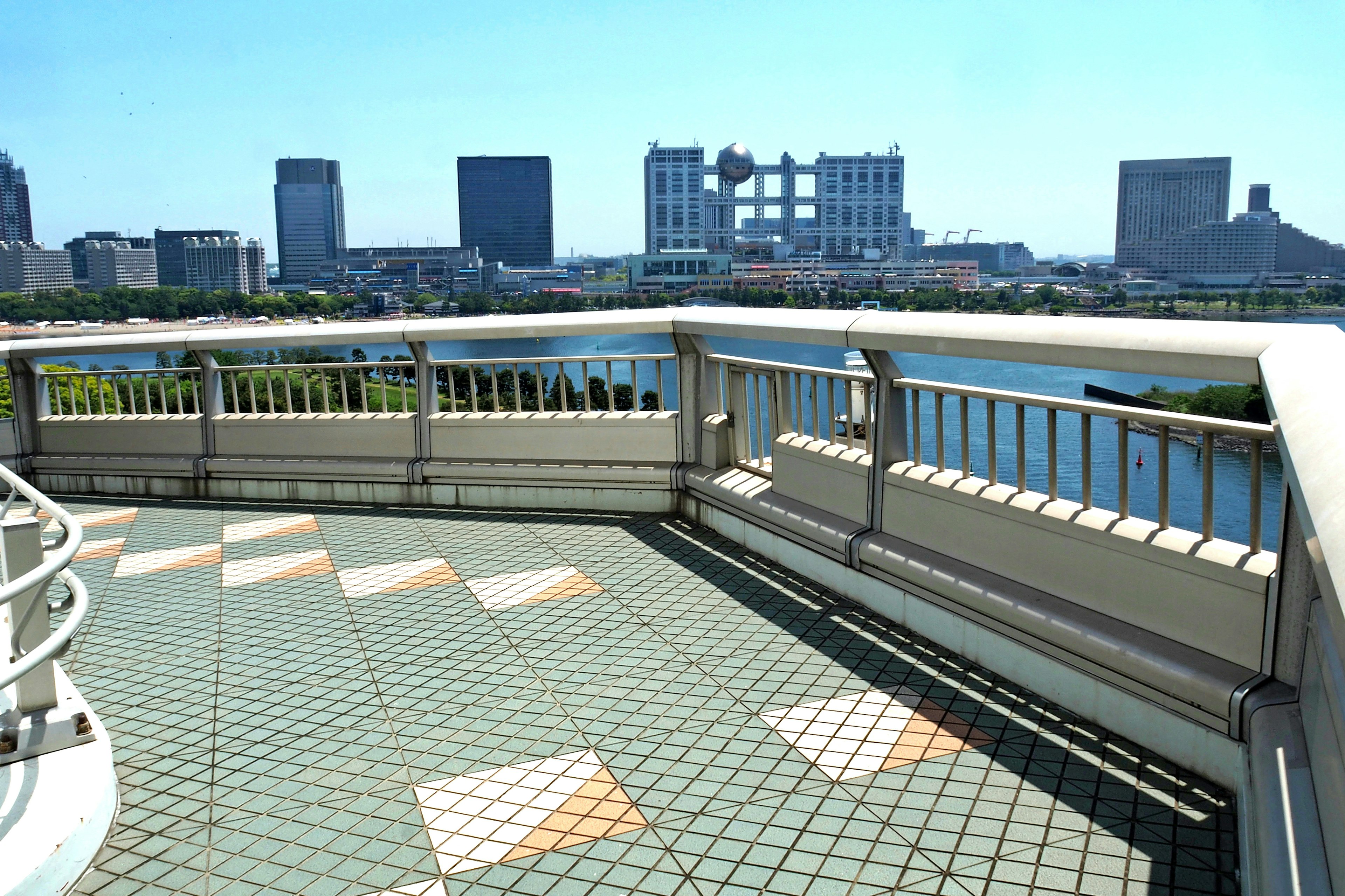 Balcony view overlooking a city skyline under a clear blue sky