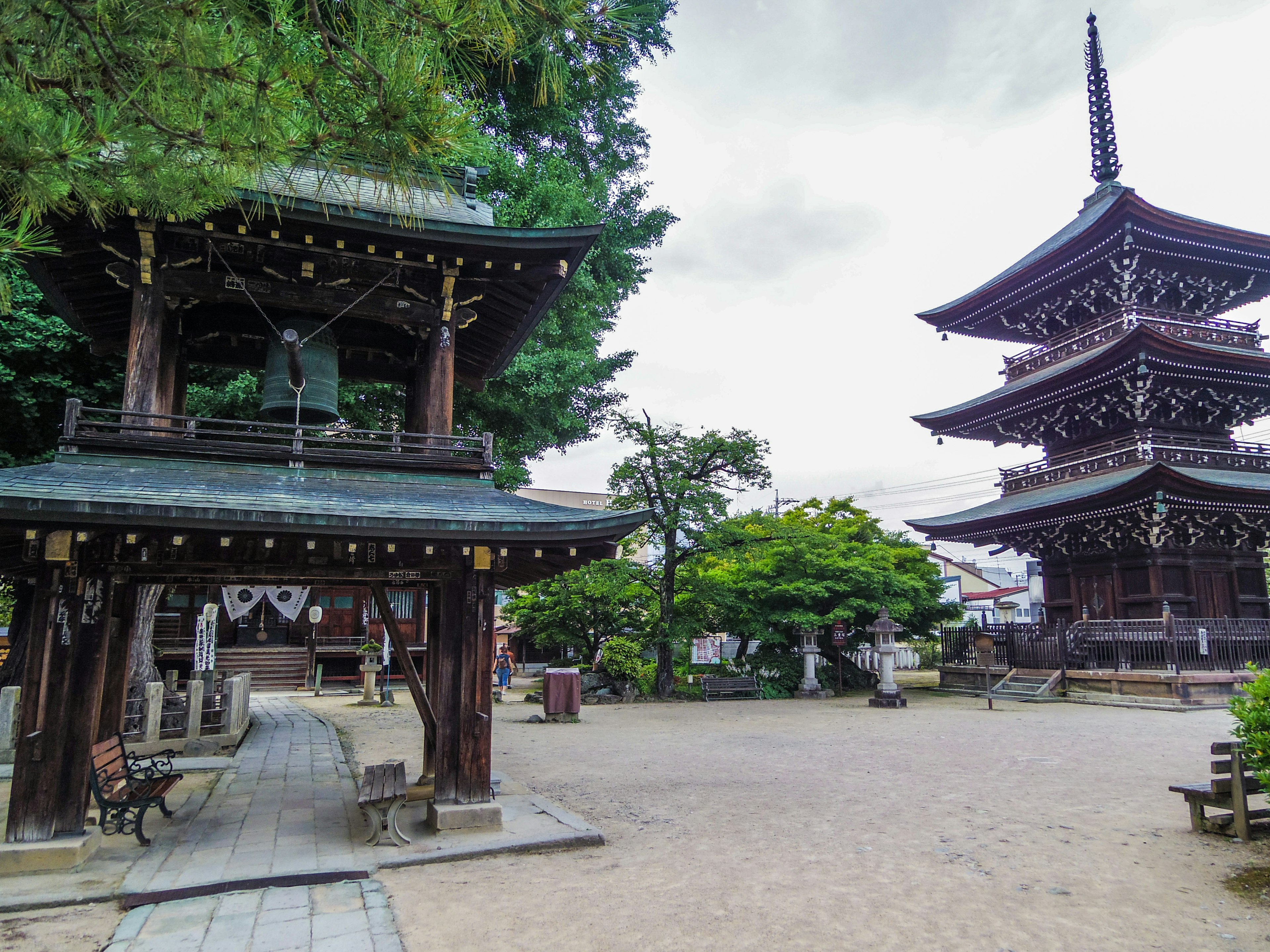 A beautiful temple courtyard featuring a bell tower and a pagoda