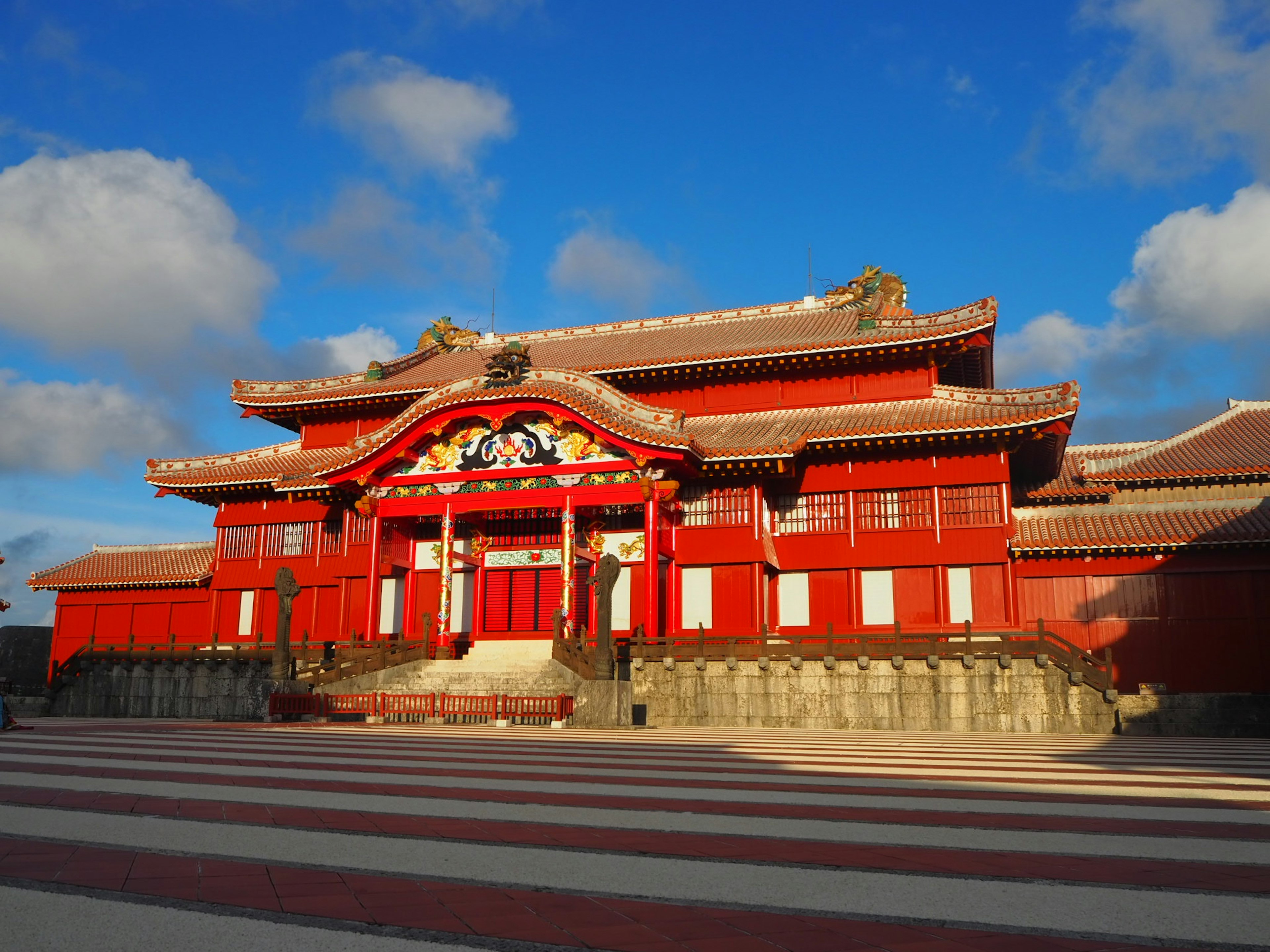 Historic Ryukyu Kingdom building in red under blue sky