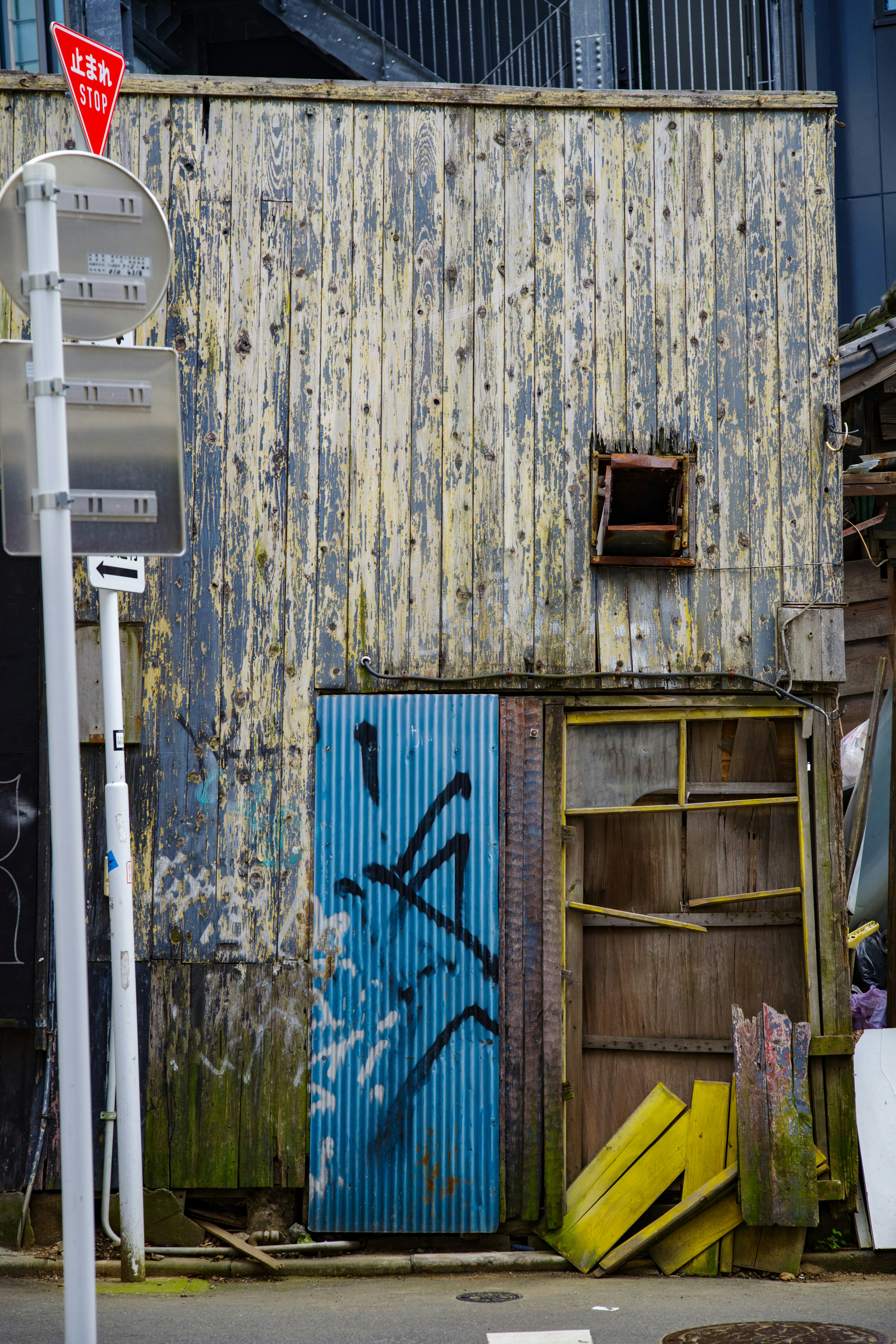 Edificio de madera envejecido con puerta azul y grafitis