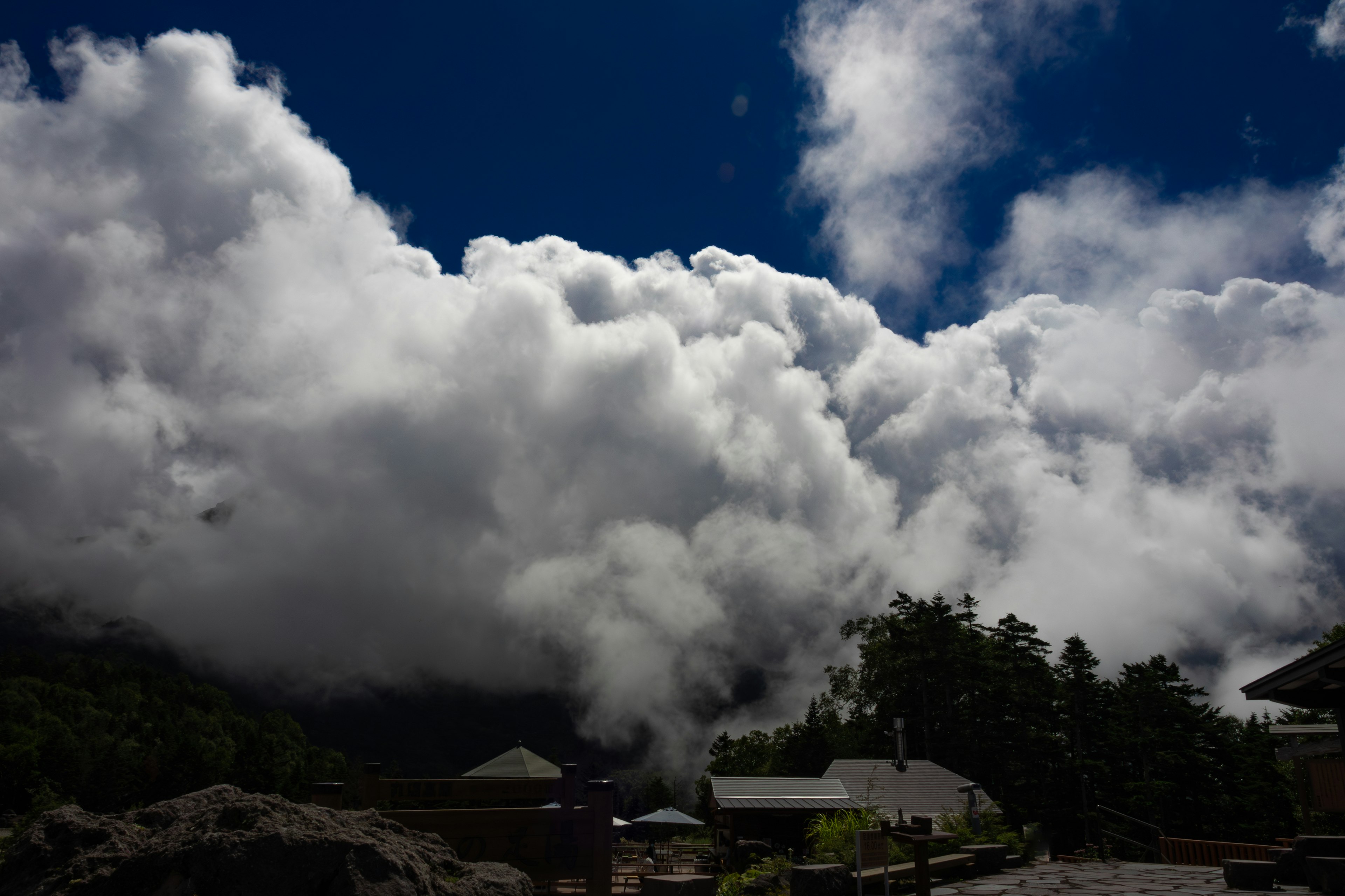 Eine Landschaft mit einem wolkenverhangenen Himmel und aufsteigendem Dampf vom Boden