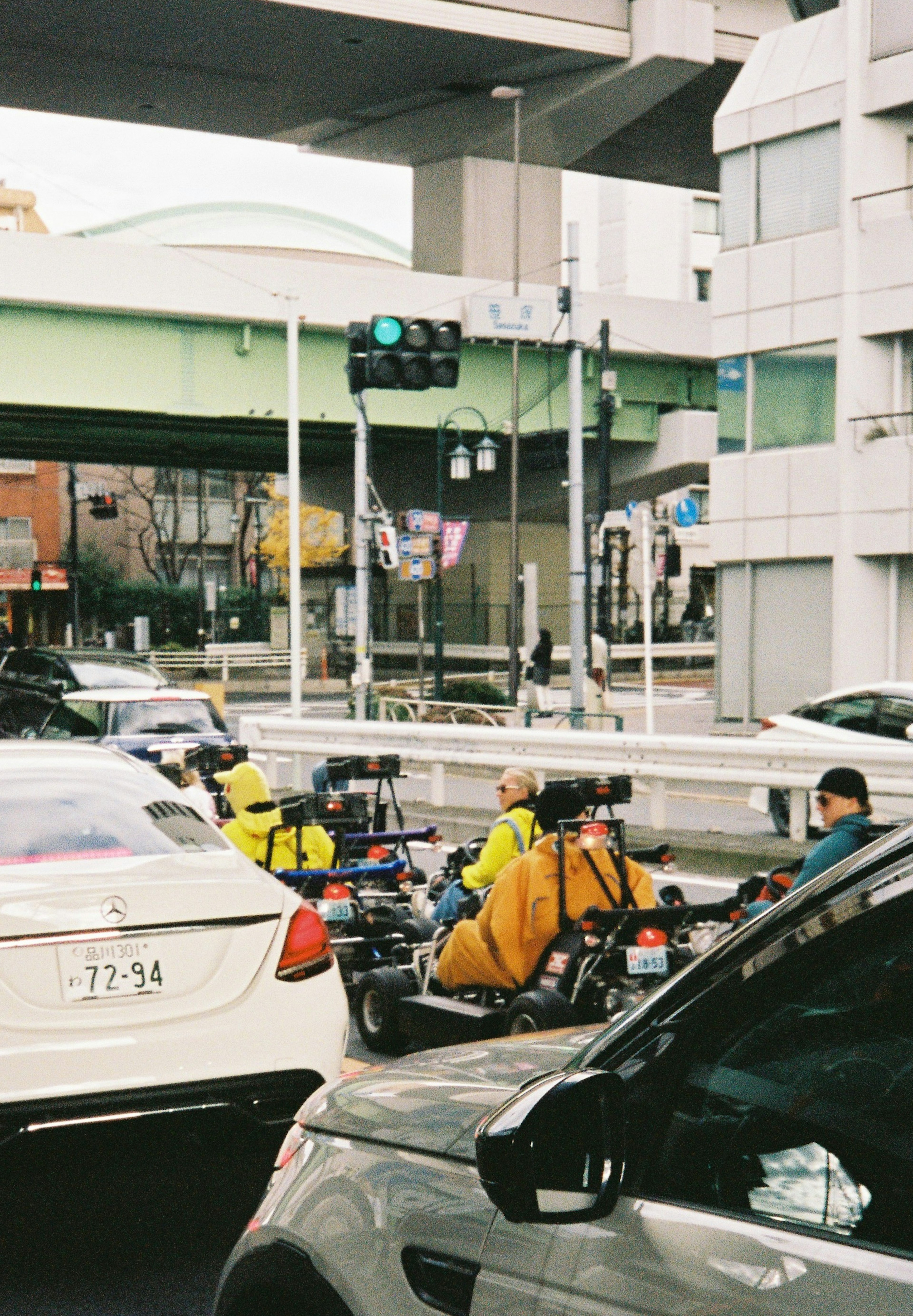 Traffic scene at an intersection featuring riders in yellow clothing