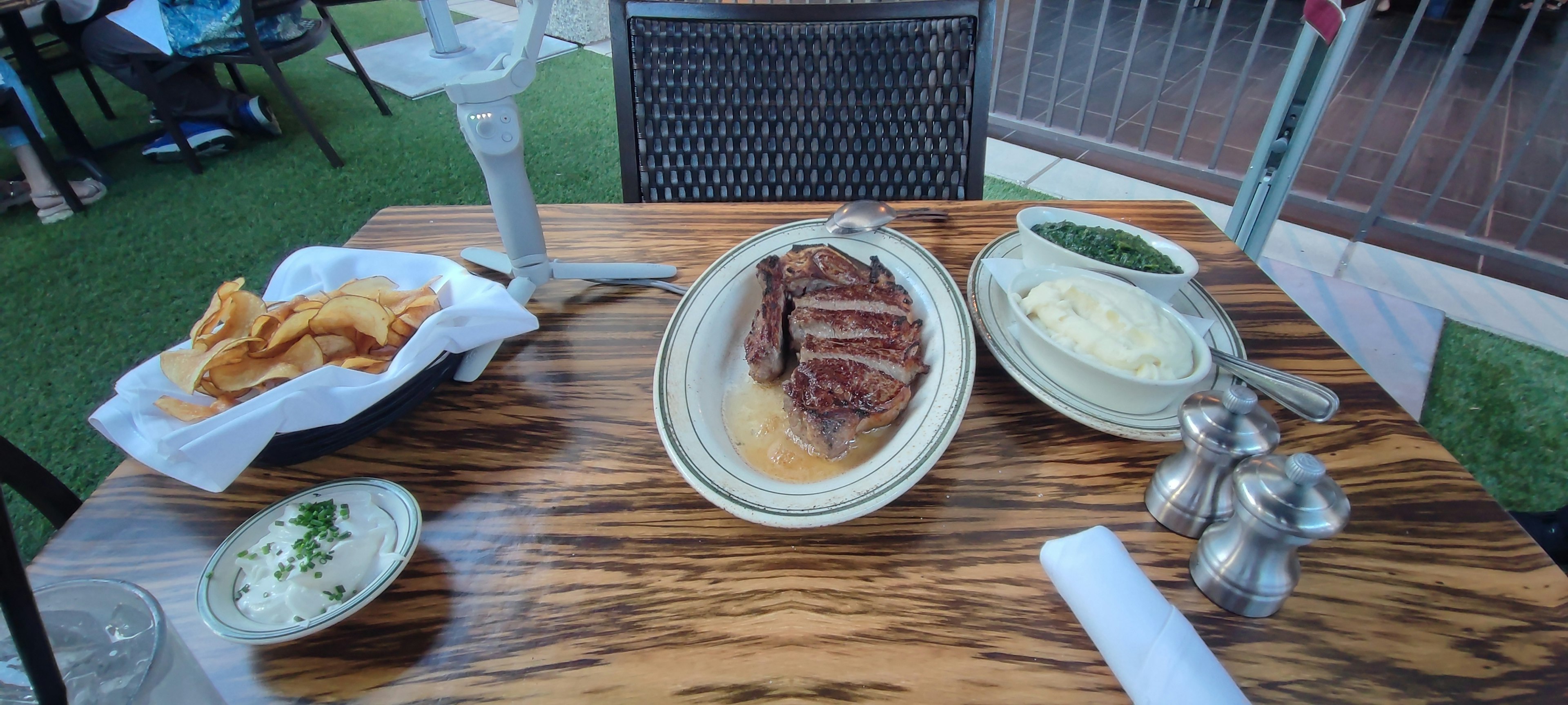 Ein Tisch mit einem Steak und Beilagen wie Kartoffelpüree und Pommes Frites