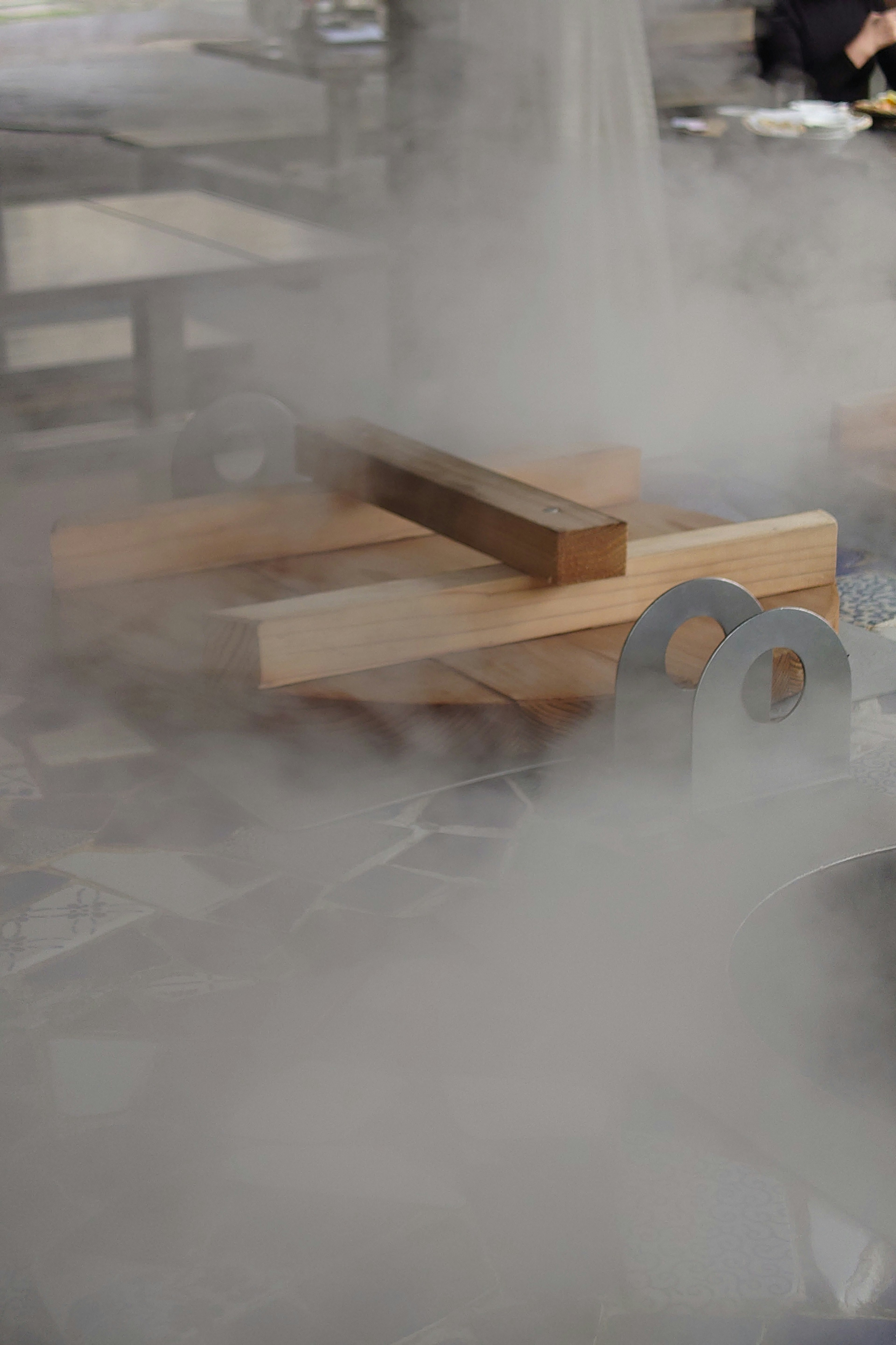 Wooden blocks and tools partially obscured by steam