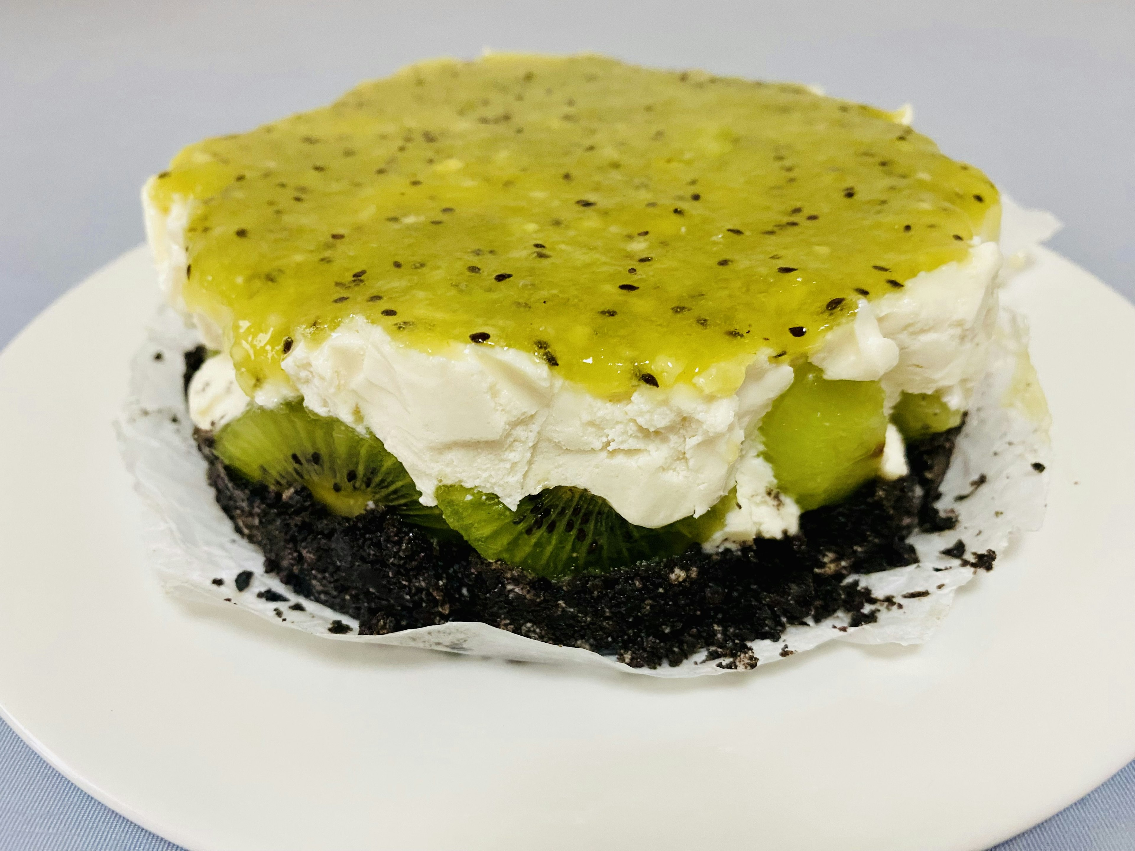 Kue berlapis dengan krim dan buah di atas kerak kue hitam