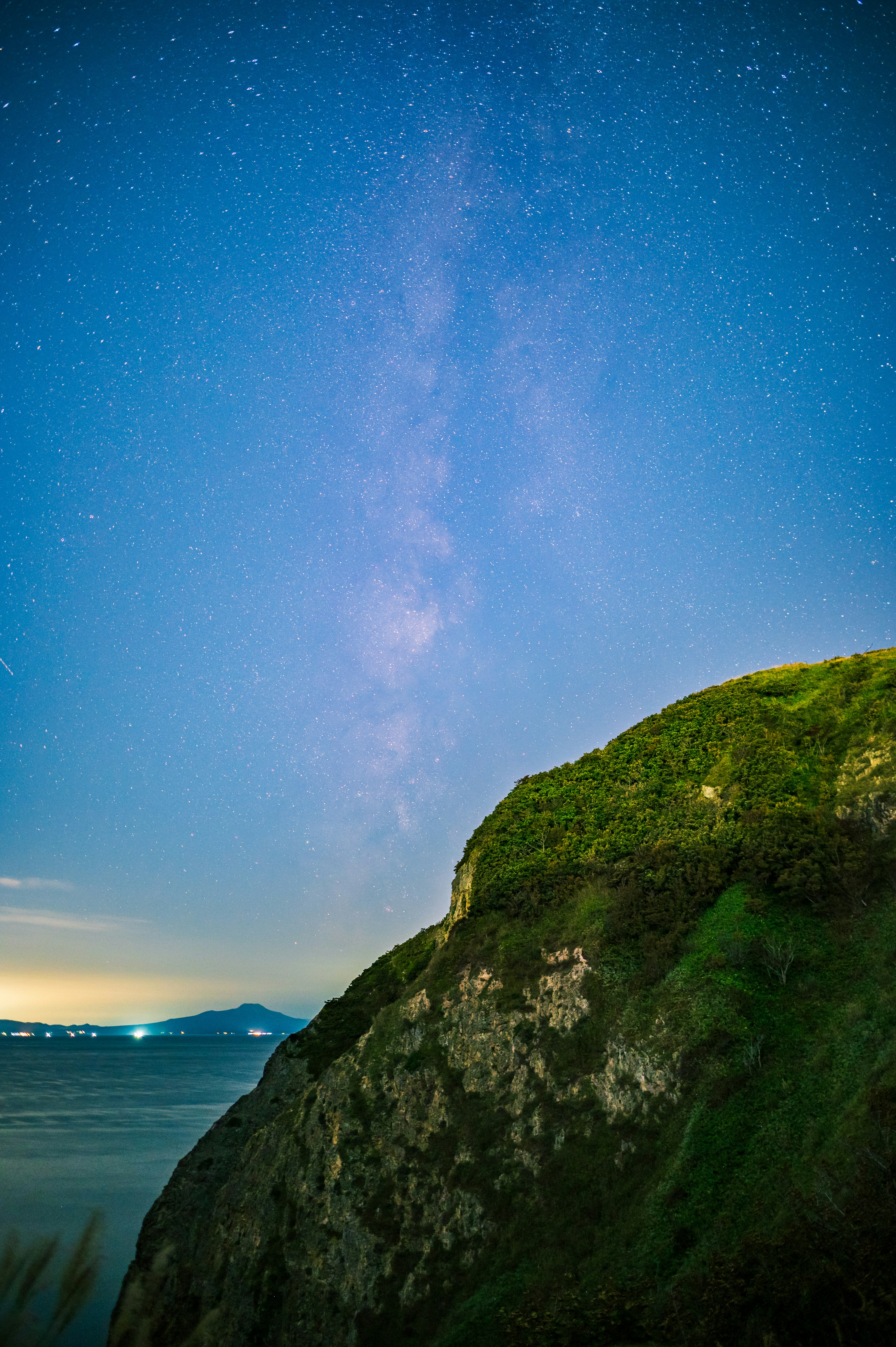 Paesaggio notturno con cielo stellato e collina verde