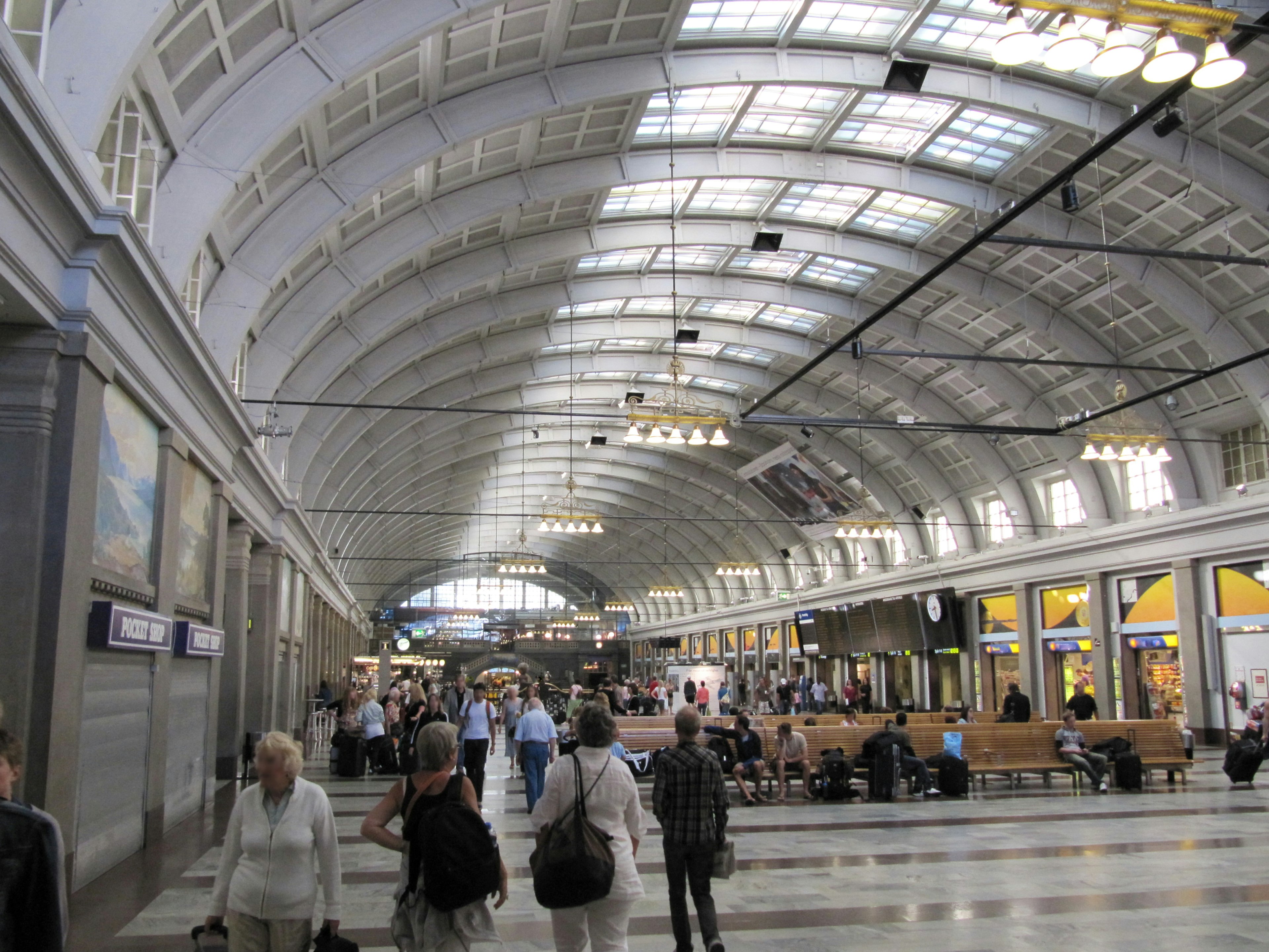 Interior of a train station with a beautiful arched ceiling many people walking