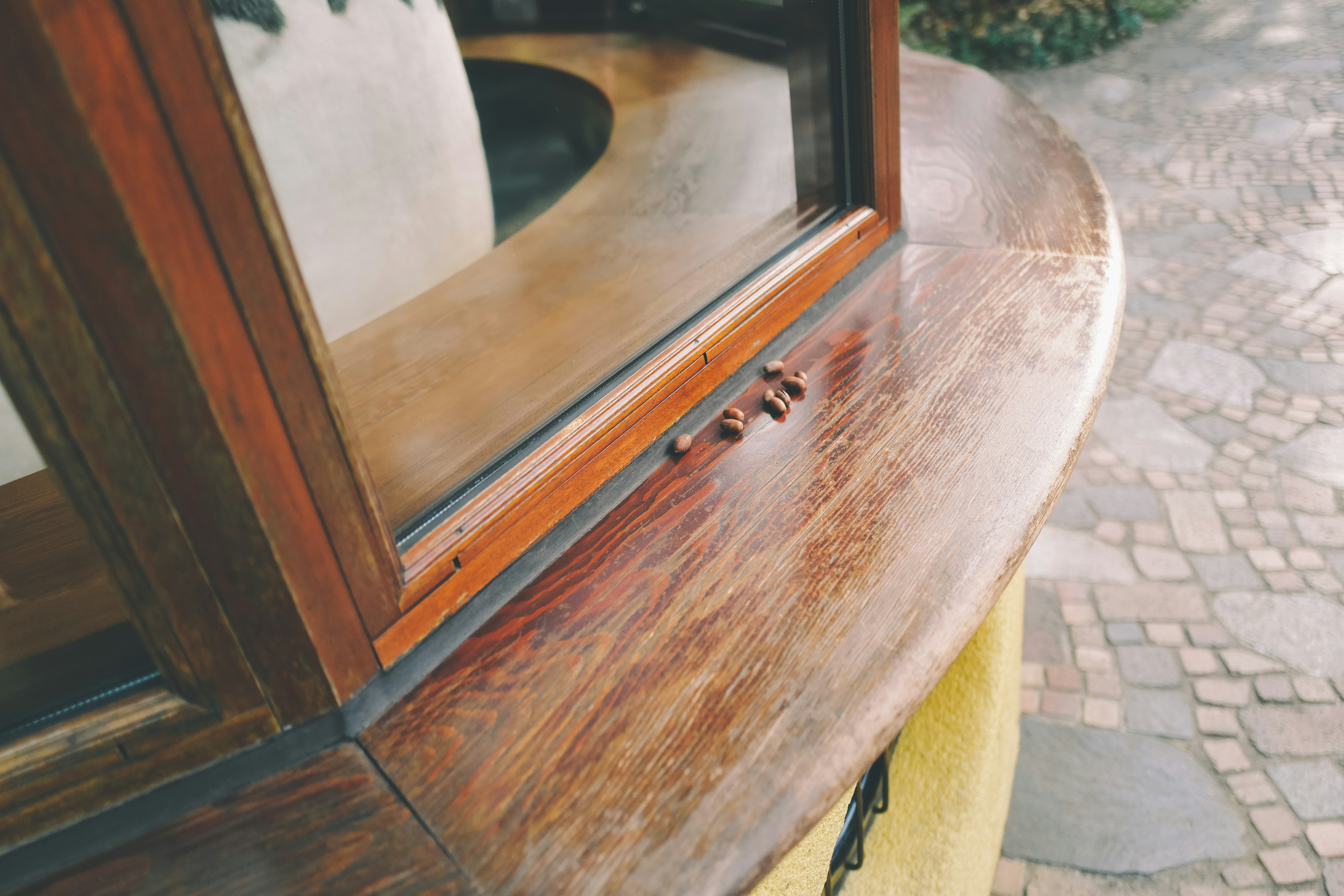 Detailed view of a wooden counter and window with a green background