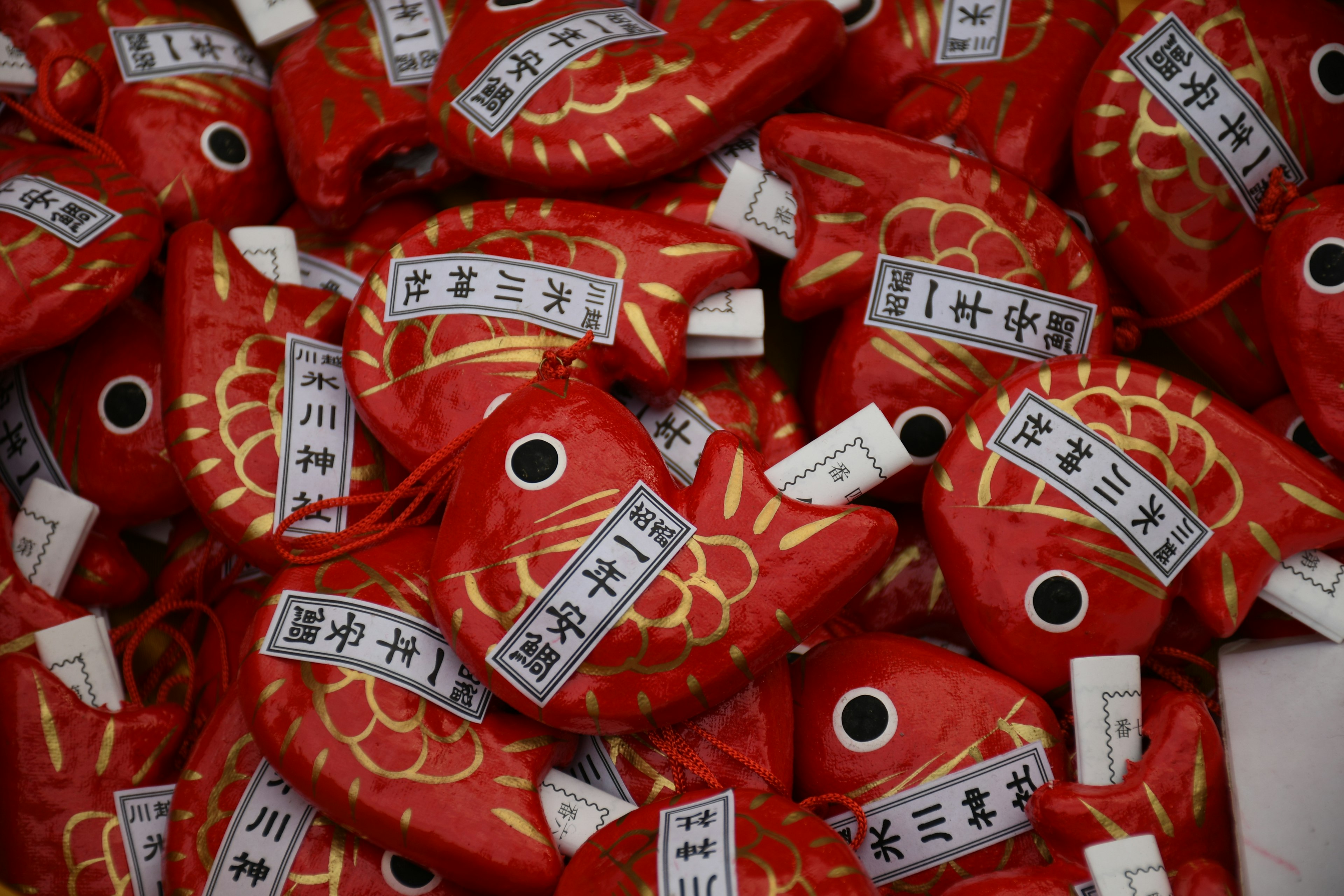 Una colección de amuletos en forma de pez rojo con inscripciones japonesas