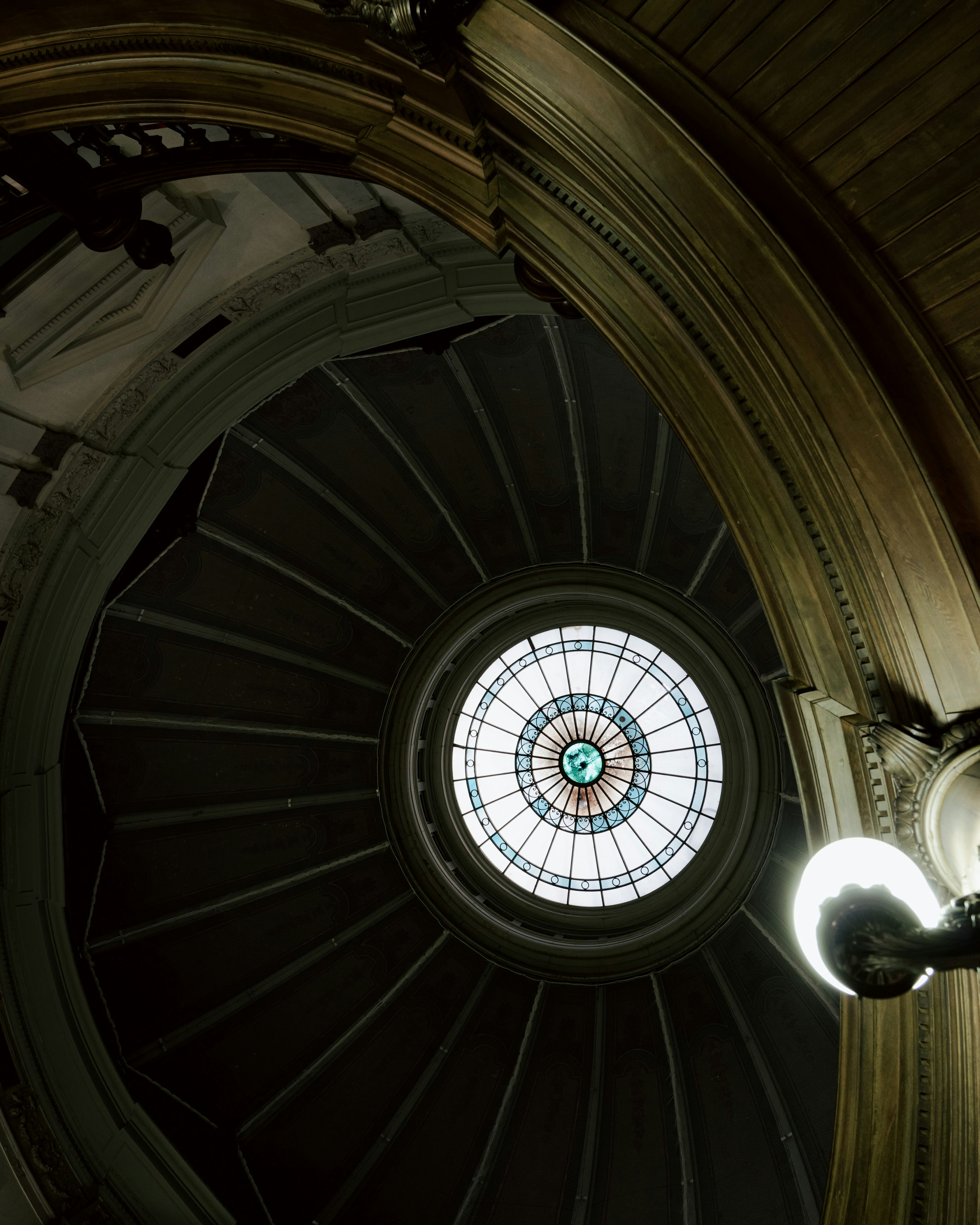 Vista dal basso di un bellissimo soffitto a cupola con una vetrata colorata e un'architettura decorativa