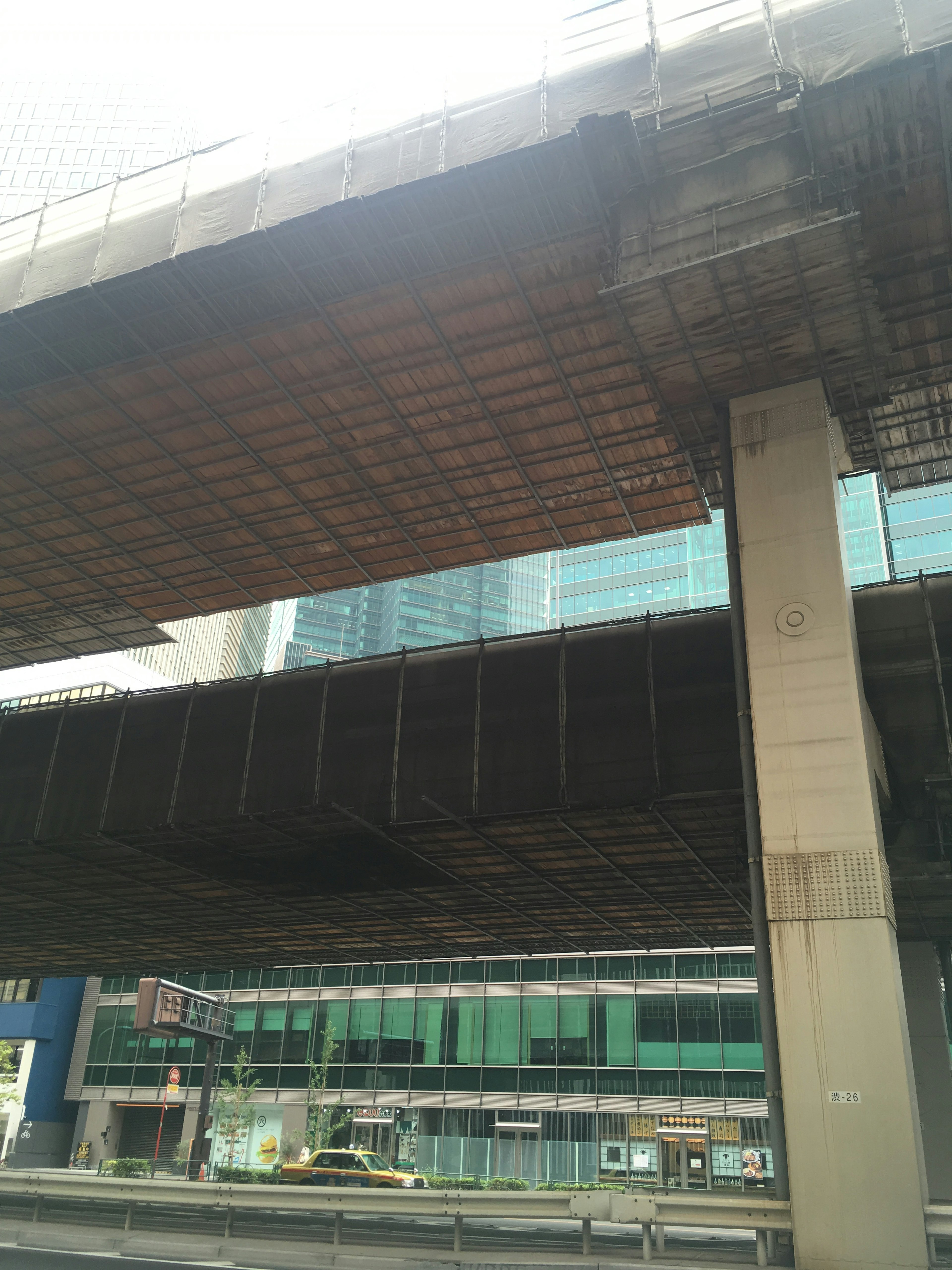 View of a concrete overpass with a glass building in the background