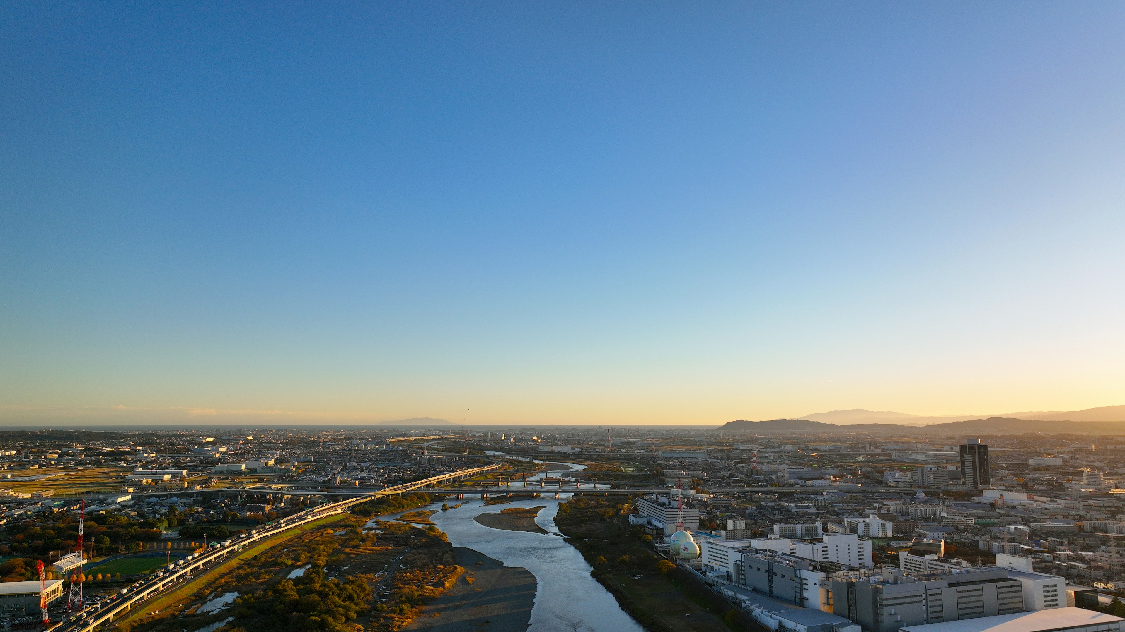 Paysage urbain avec une rivière sinueuse sous un ciel bleu