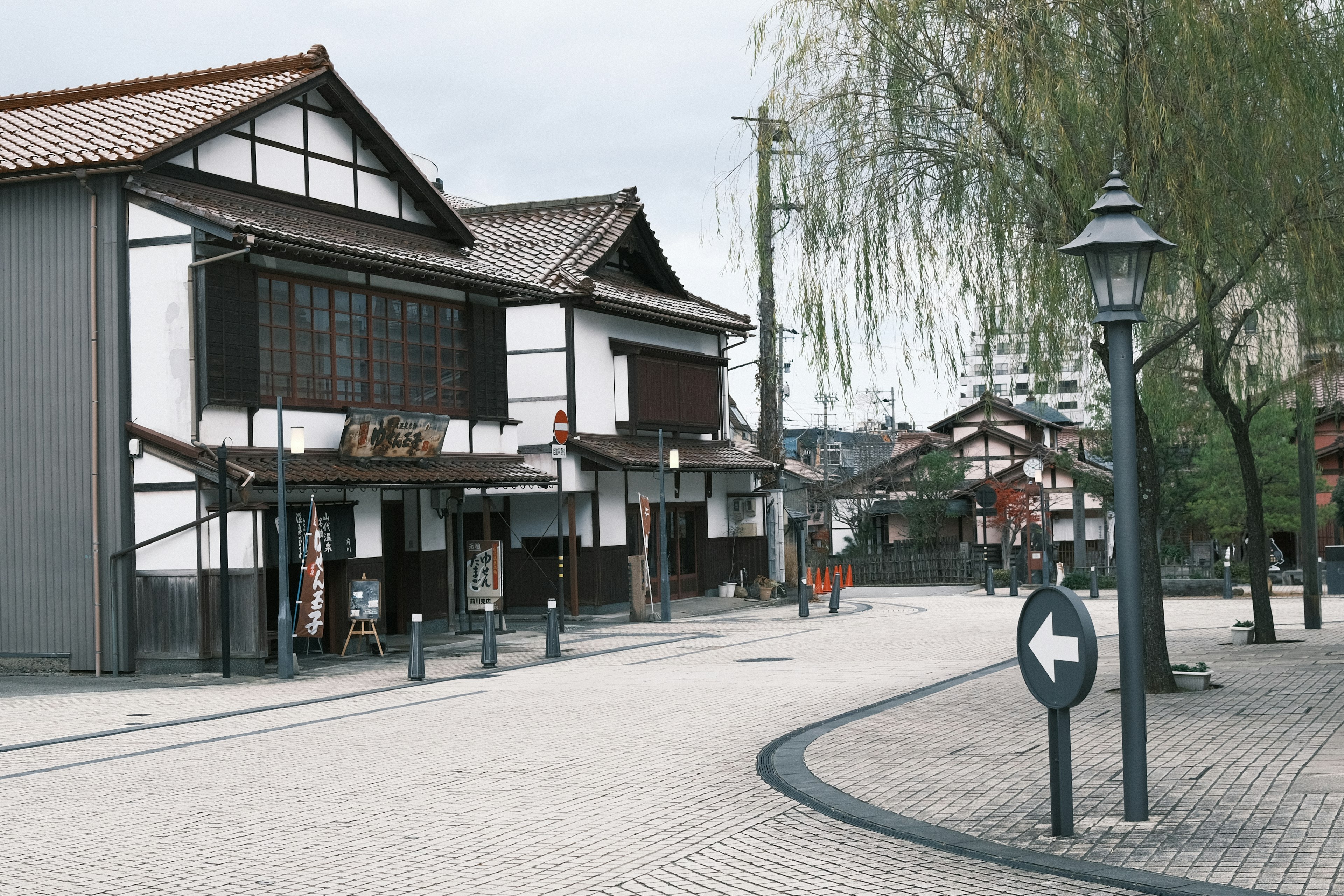 静かな街並みに伝統的な日本の建物と街灯が立ち並ぶ風景