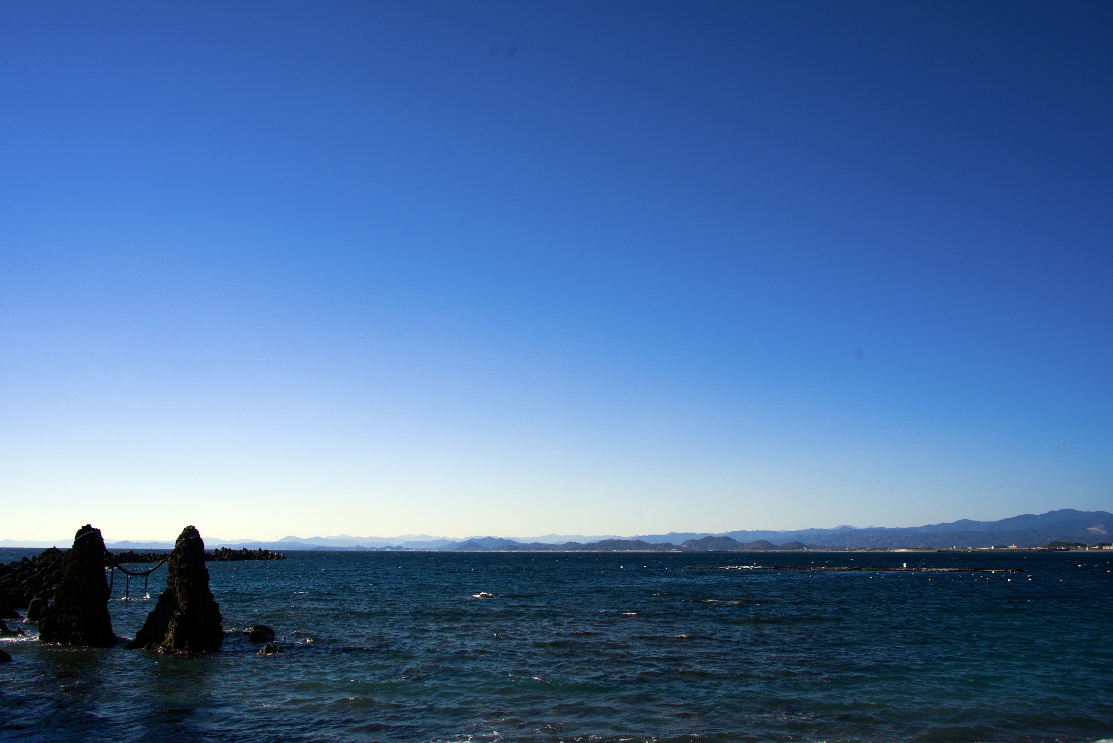 Silhouette von Felsen vor einem blauen Himmel und einer Ozeanlandschaft