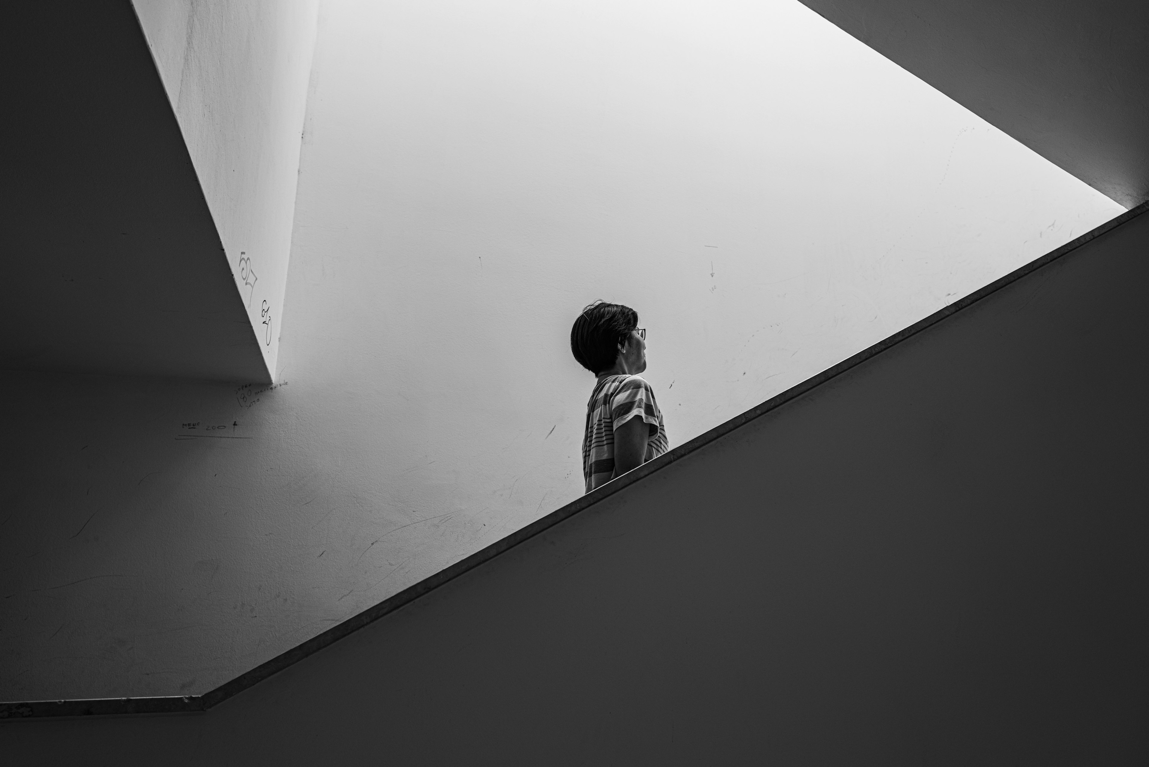 Personne marchant dans un escalier avec une composition géométrique en noir et blanc