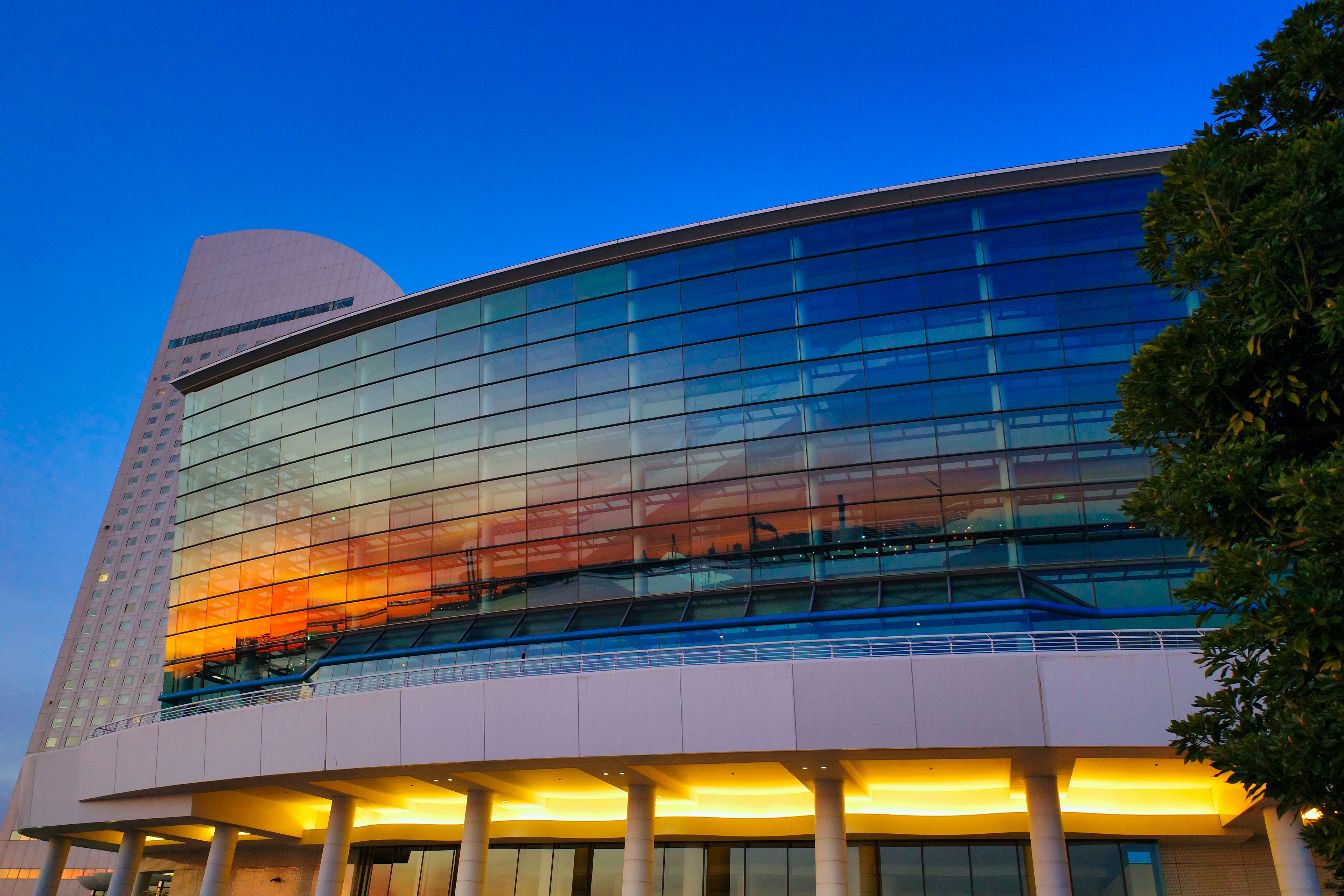 Modern glass building reflecting sunset colors