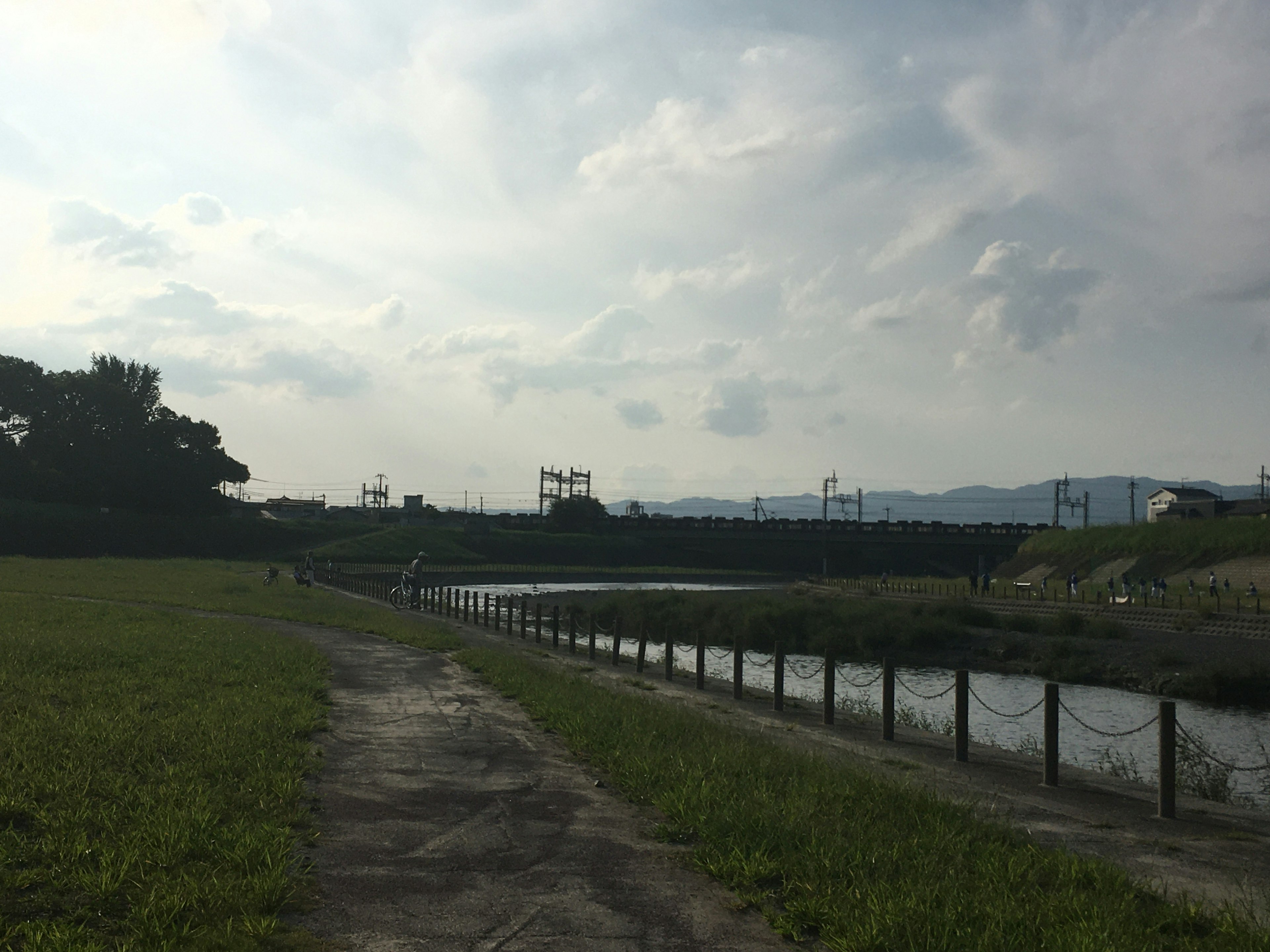 Paisaje sereno junto al río con nubes en el cielo azul